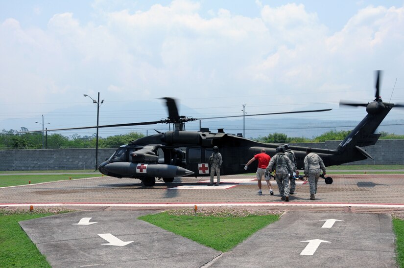 In response to a Honduran government medical evacuation (MEDEVAC) request, personnel from the 1-228th Aviation Regiment and the Joint Task Force-Bravo Medical Element load an automobile accident victim onto a U. S. Army UH-60 Blackhawk MEDEVAC helicopter as they prepare to airlift him to the Hospital Militar in Tegucigalpa, Honduras from the Joint Task Force- Bravo Medical Element's helicopter pad at Soto Cano Air Base, May 13, 2014.  A vehicle traveling west on Honduras Highway CA-5 about 13 miles outside of Comayagua was struck from behind by a tractor trailer truck.  The 18-wheeler subsequently pushed the vehicle into the trailer of another tractor trailer crushing the vehicle.  (Photo by U. S. Air National Guard Capt. Steven Stubbs)