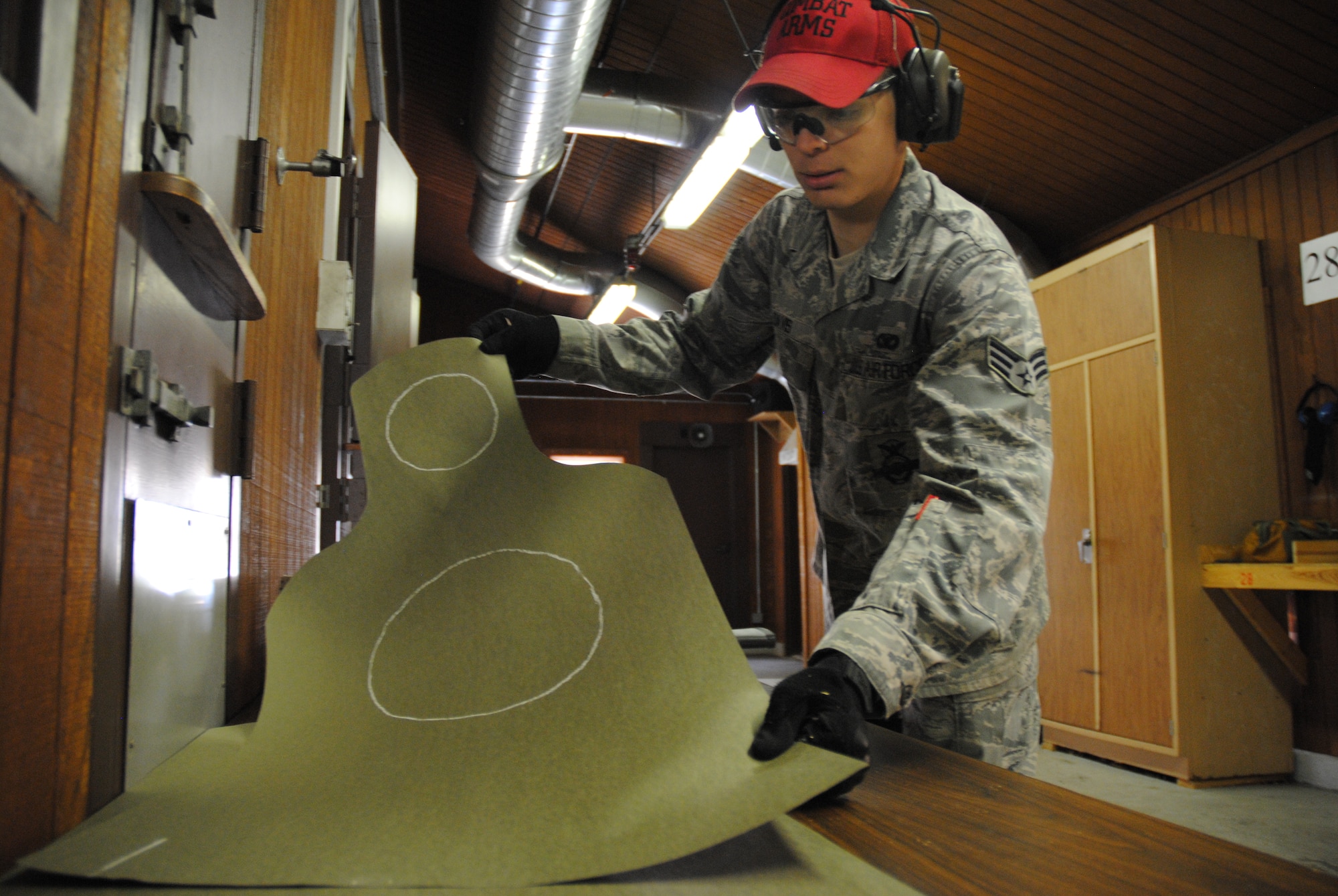Senior Airman Bret Davis, 319th Security Forces Combat Arms instructor, gets another paper target ready for another round of competition during the 2014 Police Week Commanders’ Shoot held May 15, 2014, at the firing range on Grand Forks Air Force Base, N.D. The stress shooting competition incorporated challenges such as hostages placed between targets. (U.S. Air Force photo/Staff Sgt. Luis Loza Gutierrez)