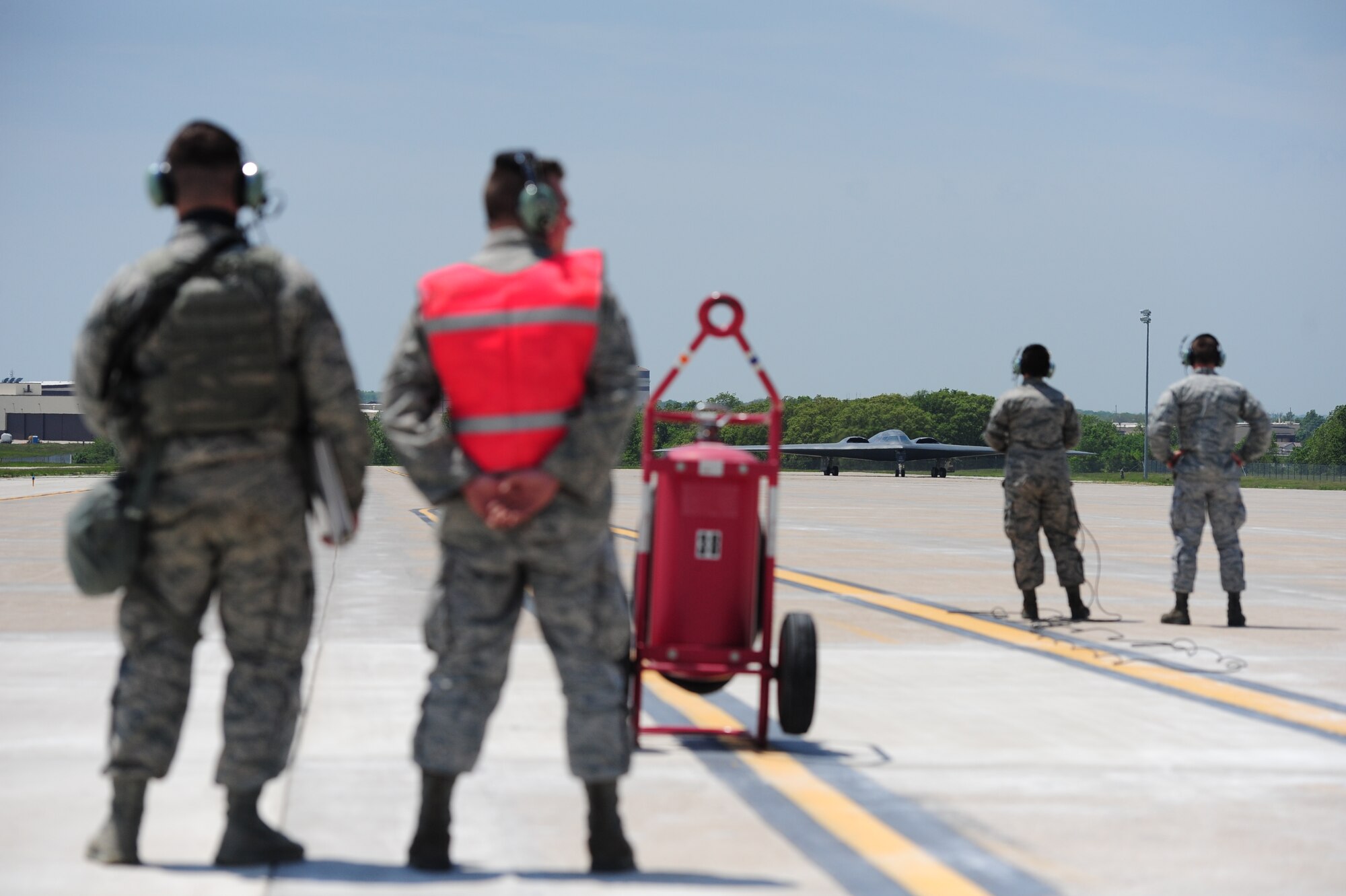 Crew chiefs from the 509th Aircraft Maintenance Squadron wait for a B-2 Spirit to taxi the flightline as part of CONSTANT VIGILANCE at Whiteman Air Force Base, Mo., May 19, 2014. Crew chiefs from the 509th Aircraft Maintenance Squadron are responsible for inspecting, troubleshooting and maintaining Whiteman's B-2 Spirits, ensuring the aircraft are combat ready to support global strike operations and nuclear deterrence. (U.S. Air Force photo by Staff Sgt. Nick Wilson/Released)