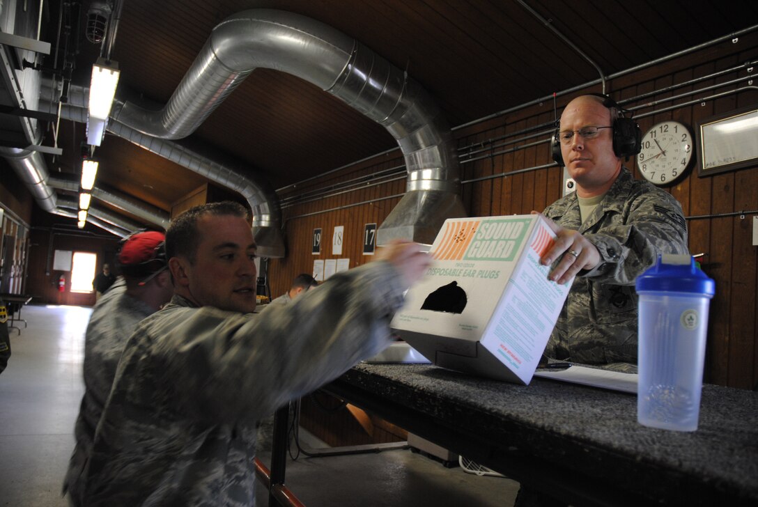 (Left) Capt. James Davern, 319th Force Support Squadron, grabs a pair of disposable ear plugs prior to the start of the 2014 Police Week Commanders’ Shoot held May 15, 2014, at the firing range on Grand Forks Air Force Base, N.D. All shooters were required to wear eye and hearing protection during the competition put on by 319th Security Force Squadron. (U.S. Air Force photo/Staff Sgt. Luis Loza Gutierrez)