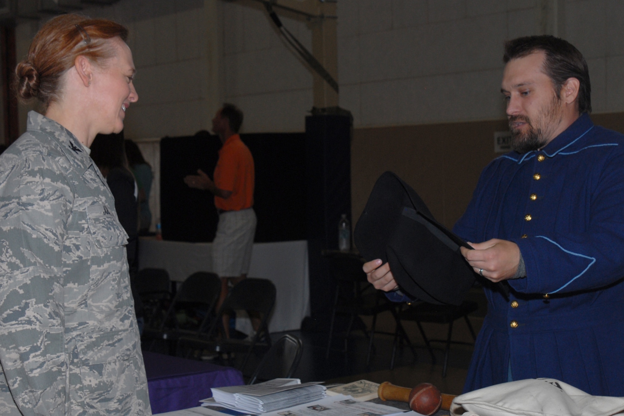 GOODFELLOW AIR FORCE BASE, Texas -- Cory Robinson, Fort Concho Visitor and Volunteer Services coordinator, shows Col. Kimberlee P. Joos, 17th Training Wing Commander, an old uniform hat during the Volunteer Fair at Carswell Field House here May 21. Fort Concho received 17 volunteers during the Volunteer Fair. (U.S. Air Force photo/ Staff Sgt. Laura R. McFarlane)