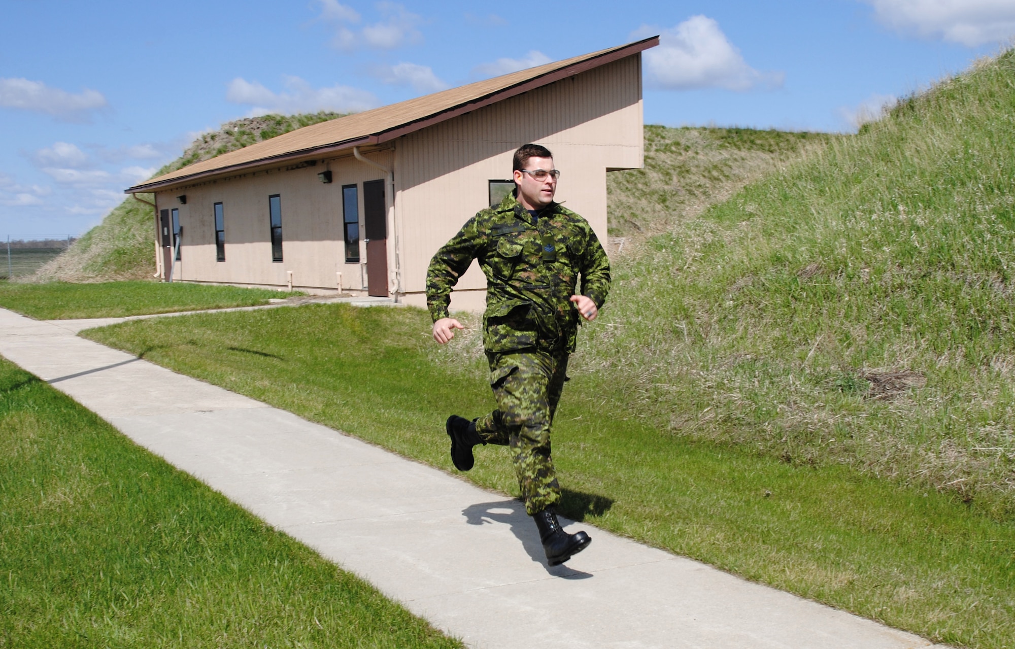 Royal Canadian Air Force Master Cpl. Justin Chapman sprints to the second firing station during the 2014 Police Week Commanders’ Shoot held May 15, 2014, at the firing range on Grand Forks Air Force Base, N.D. Chapman competed with two American Airmen who work with him at Cavalier Air Force Station, N.D. (U.S. Air Force photo/Staff Sgt. Luis Loza Gutierrez)
