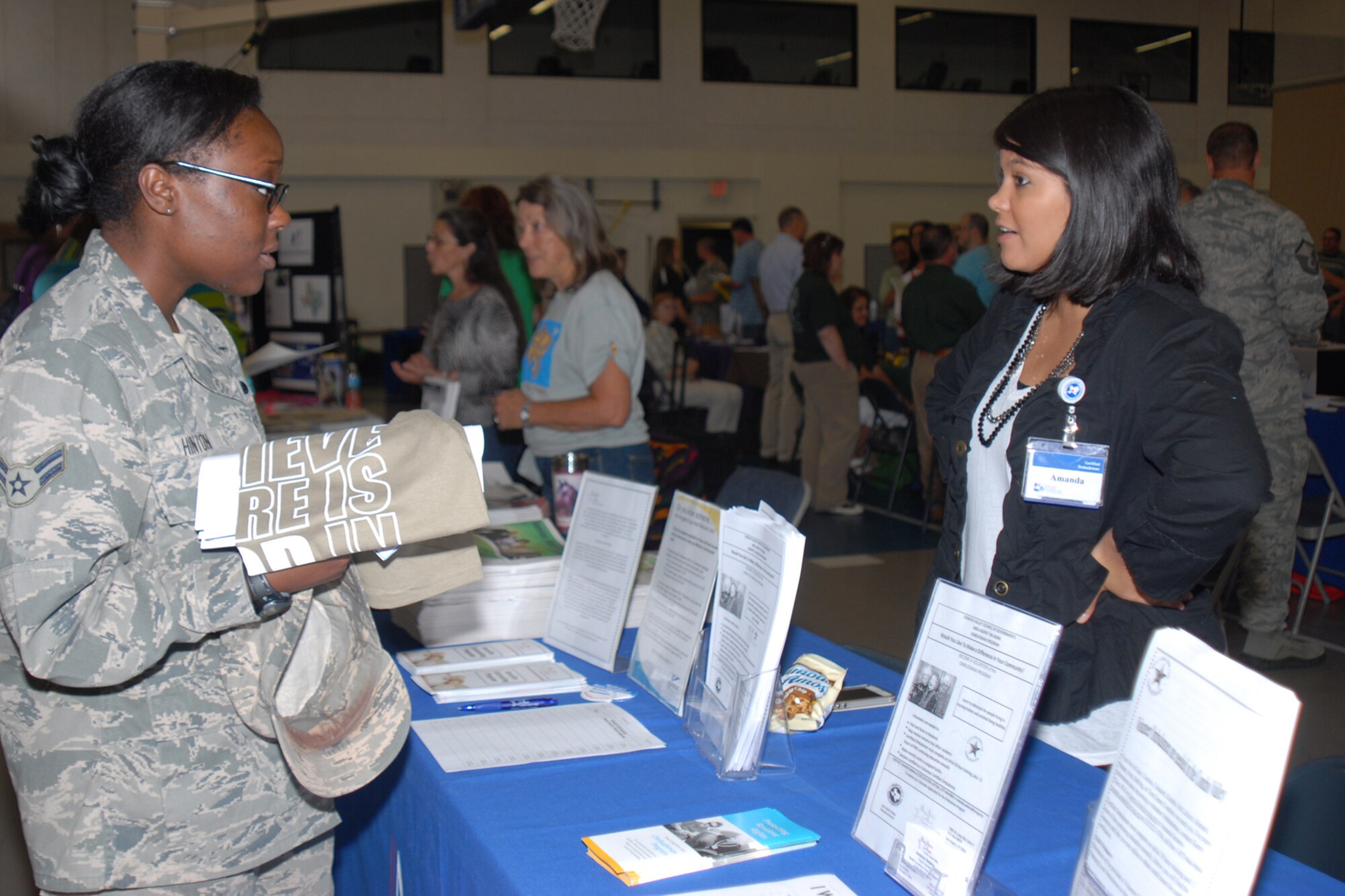 GOODFELLOW AIR FORCE BASE, Texas -- Airman 1st Class Jebree M. Hinton, 17th Training Wing Legal Office military justice paralegal, talks with Amanda K. Sedeno, Area Agency on Aging of the Concho Valley Ombudsmen and Benefits Counseling Program specialist, about volunteer opportunities during the Volunteer Fair at Carswell Field House here May 21. Area Agency on Aging of the Concho Valley was one of 27 organizations seeking volunteers. (U.S. Air Force photo/ Staff Sgt. Laura R. McFarlane)