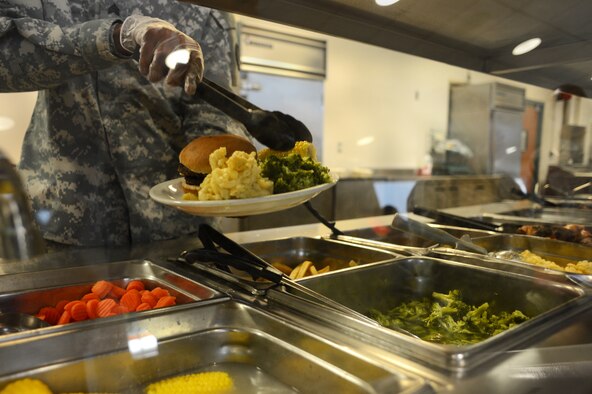 A U.S. Army soldier serves dinner during an Airman appreciation dinner at the Chief Master Sgt. Emerson E. Williams dining facility at Shaw Air Force Base, S.C., May 21, 2014. The Airman appreciation dinner gives squadron commanders the opportunity to visit with their junior enlisted Airmen and get to know them personally as well as professionally. (U.S. Air Force photo by Airman 1st Class Jonathan Bass/Released)