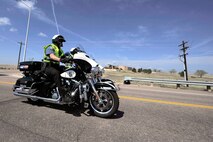 SCHRIEVER AIR FORCE BASE, Colo. -- Approximately 50 police and civilian riders from various locations throughout the front range exit Schriever's north gate after a quick transit through the base on 22 May.  The ride was in honor of Police Week and Law Enforcement Officers who have lost their lives in the line of duty. (U.S. Air Force Photo/Dennis Rogers)