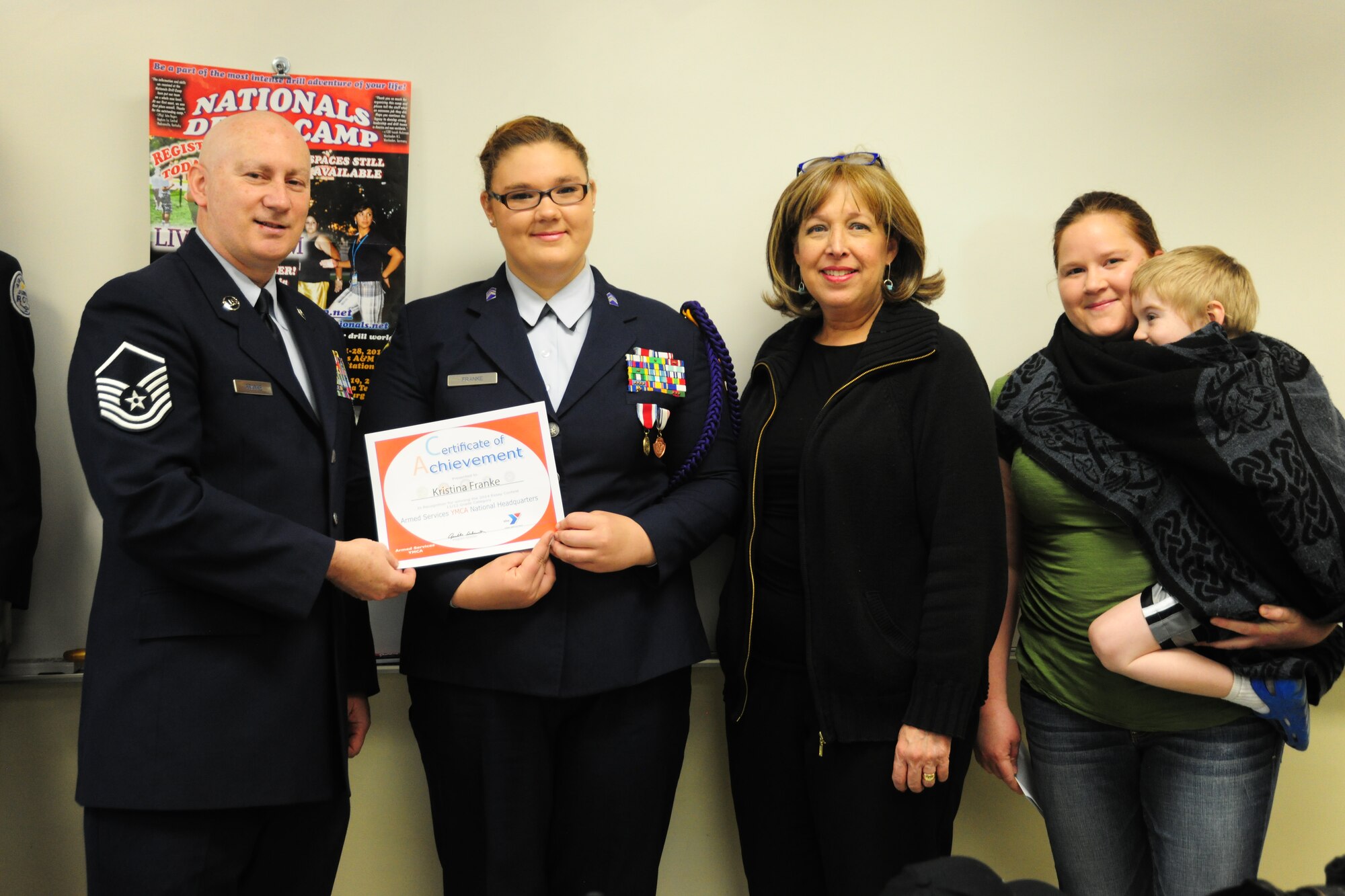 Master Sgt. John Franke and his daughter, Air Force JROTC Cadet Lt. Kristina Franke, hold her certificate of achievement for winning the Armed Services YMCA National Essay Contest on May 15, 2014, at the Arlington Career Center, Va. Kristina's essay said her father Franke, Joint Base Andrews, Md., 11th Security Forces Group superintendent of resources, is her military hero. Giselle Schnieder, ASYMCA program director, (center) presented Kristina with the award. Her mother Stephanie and her brother were there to share the moment. (U.S. Air Force photo/ Staff Sgt. Amber J. Russell)
