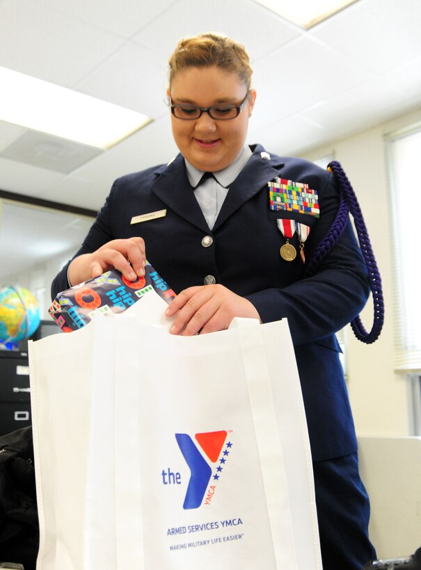 Air Force JROTC Cadet Lt. Kristina Franke, group deputy commander, tucks away her new Apple iPad after winning the Armed Services YMCA National Essay Contest on May 15, 2014, at the Arlington Career Center, Va. Kristina's essay said Master Sgt. John Franke, 11th Security Forces Group superintendent of resources, is not only her father but her military hero. (U.S. Air Force photo/ Staff Sgt. Amber J. Russell)