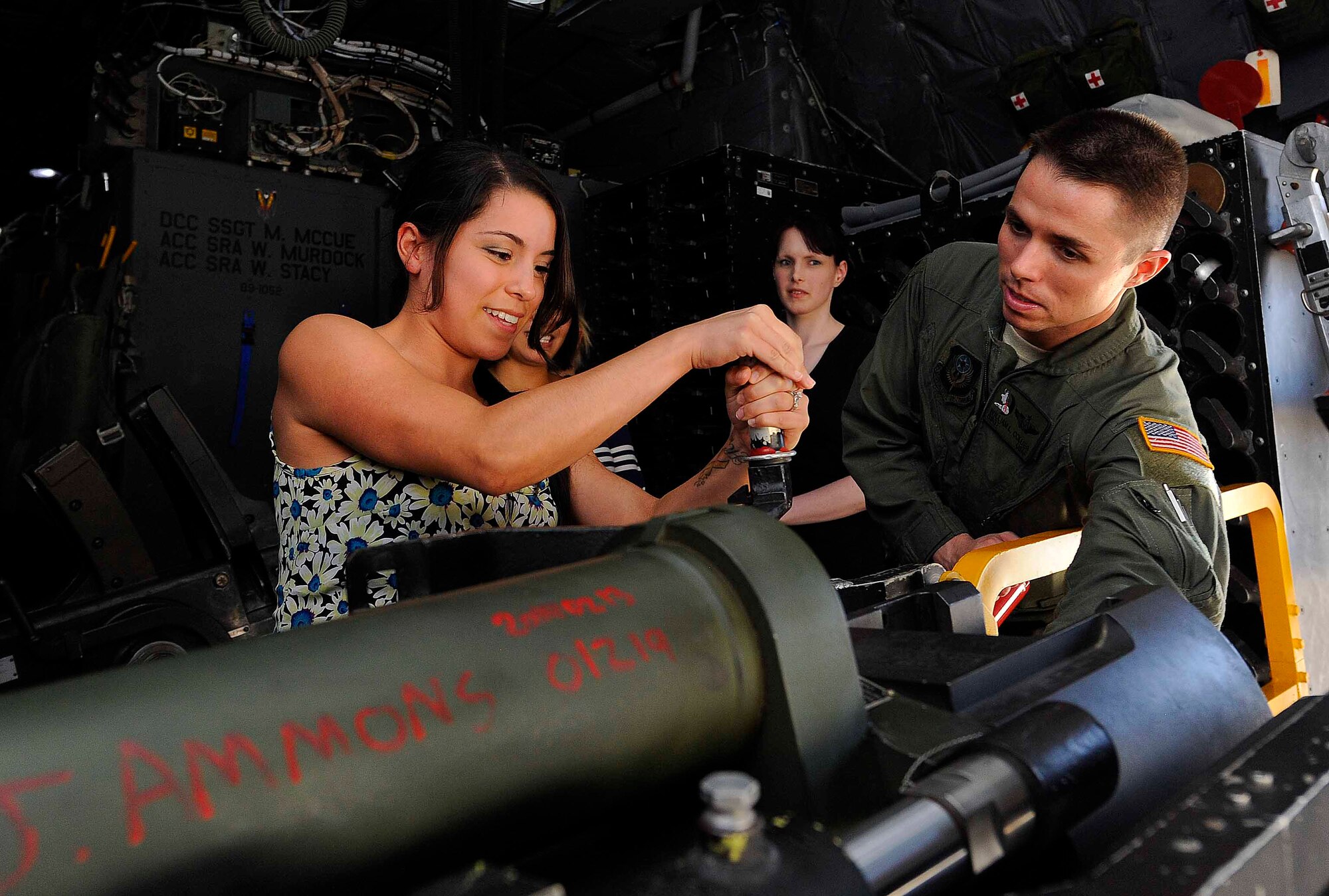 Staff Sgt. William Collier, 4th Special Operations Squadron aerial gunner, shows Arrica Gonzalezvasques how to load a bullet on an AC-130 gun-ship during a spouse’s tour on Hurlburt Field, Fla., May 21, 2014. The tour took military spouses on the flightline to learn about Hurlburt’s mission (U.S. Air Force photo/Airman 1st Class Andrea Posey)