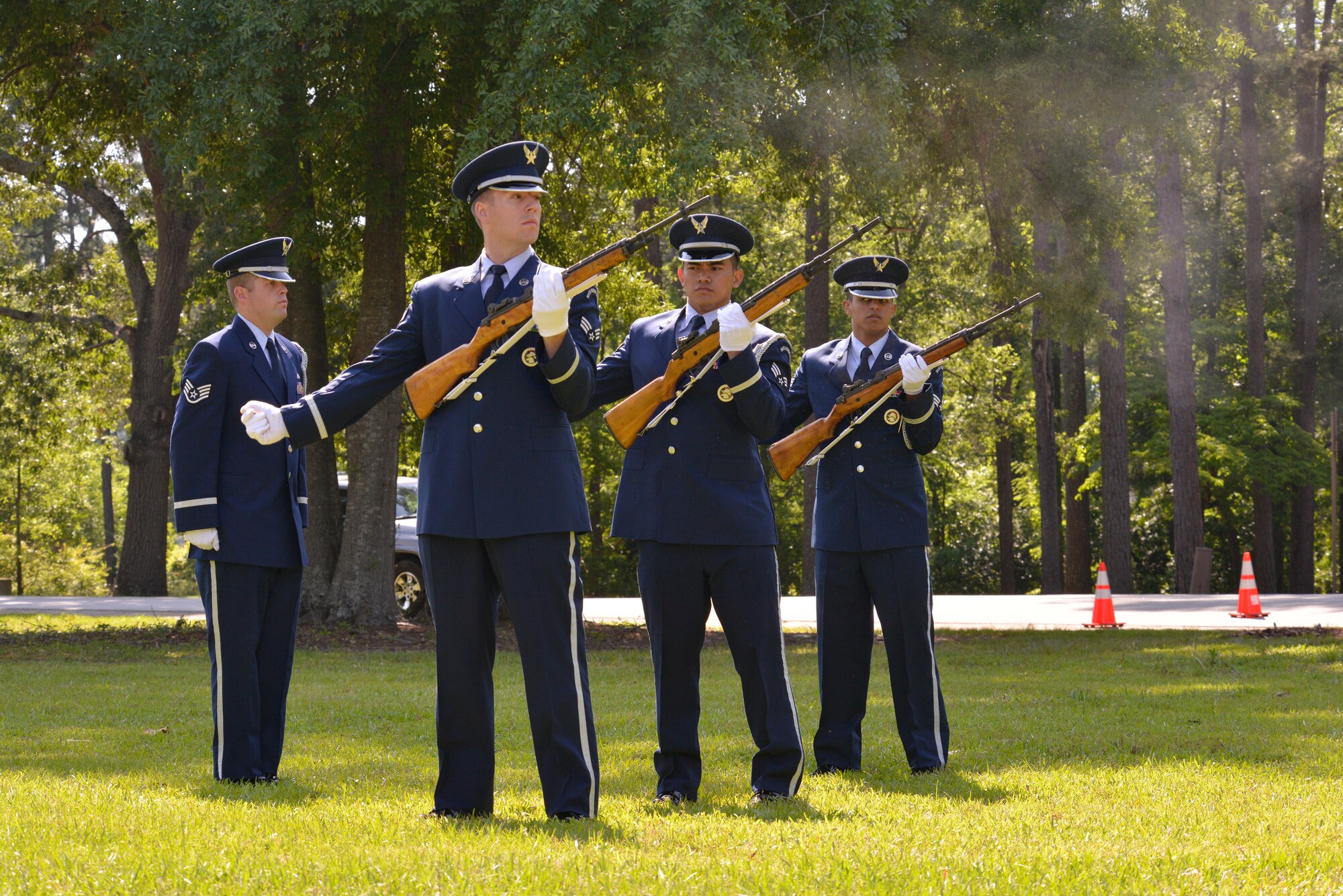 The Robins Air Force Base Honor Guard fire a salute during the Camellia Gardens Memorial Ceremony May 22, 2014. From left to right are Staff Sgt. Christopher Knowles, Senior Airman Phillip Madison, Senior Airman Sakay Tariman and Senior Airman Silvio Ortiz. U.S. Air Force photo by Ed Aspera)