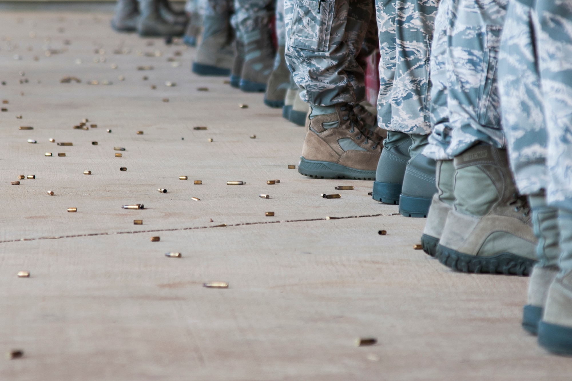 Spent bullet casings litter the ground around the boots of Airmen assigned to the 307th Security Forces Squadron, May 17, 2014, Barksdale Air Force Base, La. The Airmen are preparing to deploy in support of an Eager Lion exercise by accomplishing weapons qualification training. (U.S. Air Force photo by 2nd Lt. Monique Roux/Released)