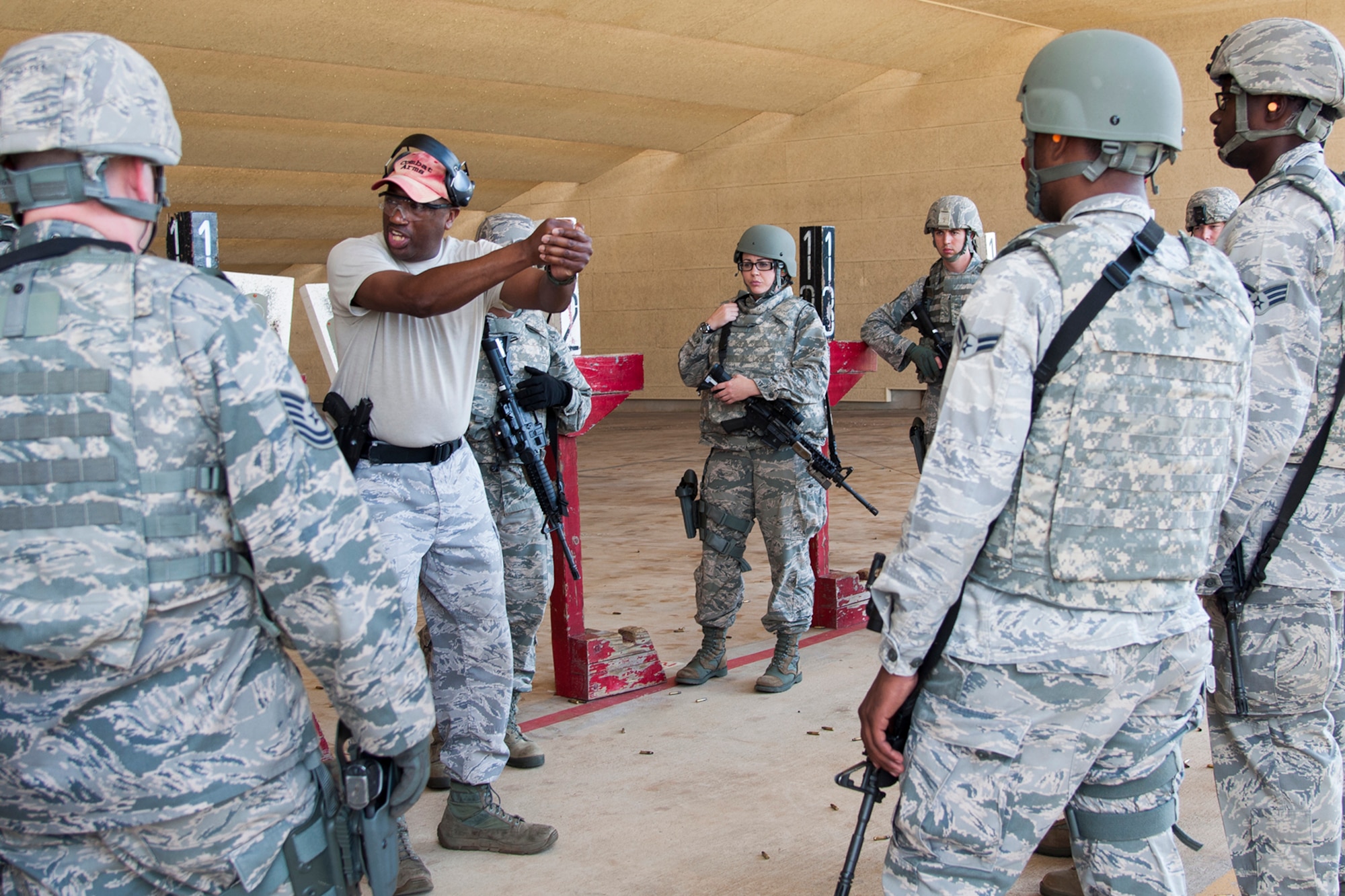 Airmen assigned to the 307th Security Forces Squadron are shown the proper stance when firing a handgun during weapons qualification training prior to leaving for a deployment in support of exercise Eager Lion, May 17, 2014, Barksdale Air Force Base, La. Roughly 6,000 U.S. troops will participate in Eager Lion, which is an exercise involving scenarios ranging from training for a humanitarian assistance to practicing integrated air and missile defense. (U.S. Air Force photo by Master Sgt. Greg Steele/Released)