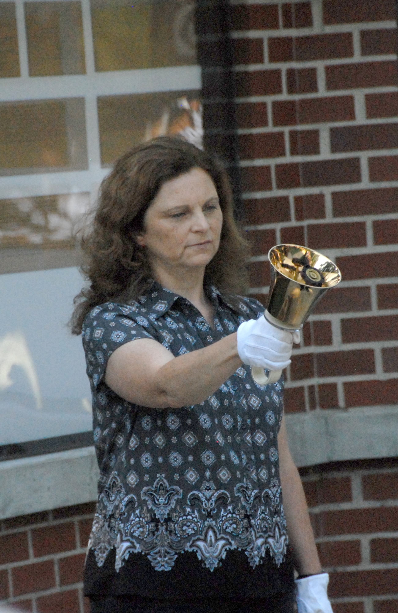Pamela Baker rings the bell in honor of each name read during the Camellia Gardens Memorial Service Thursday, May 22.  The names of 63 fallen comrades from Team Robins were added to the memorial this year.  (U.S. Air Force photo by Misuzu Allen)