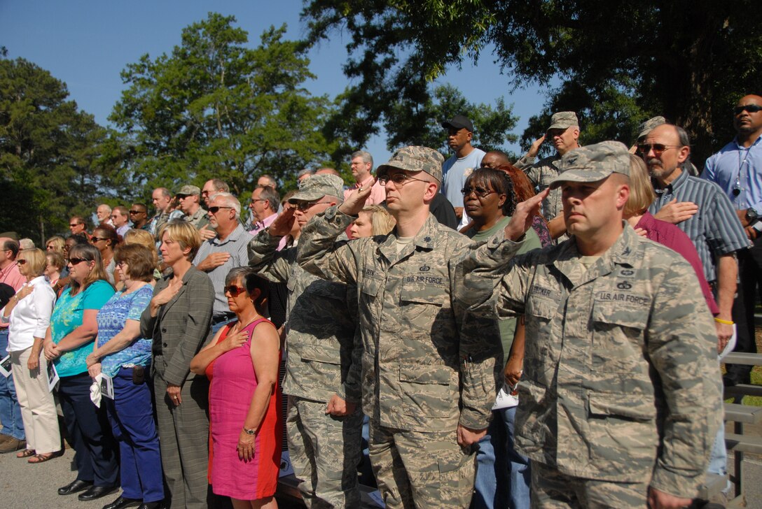 Attendees observe the singing of the national anthem during Thursday’s memorial service at Camellia Gardens.  (U.S. Air Force photo by Misuzu Allen)