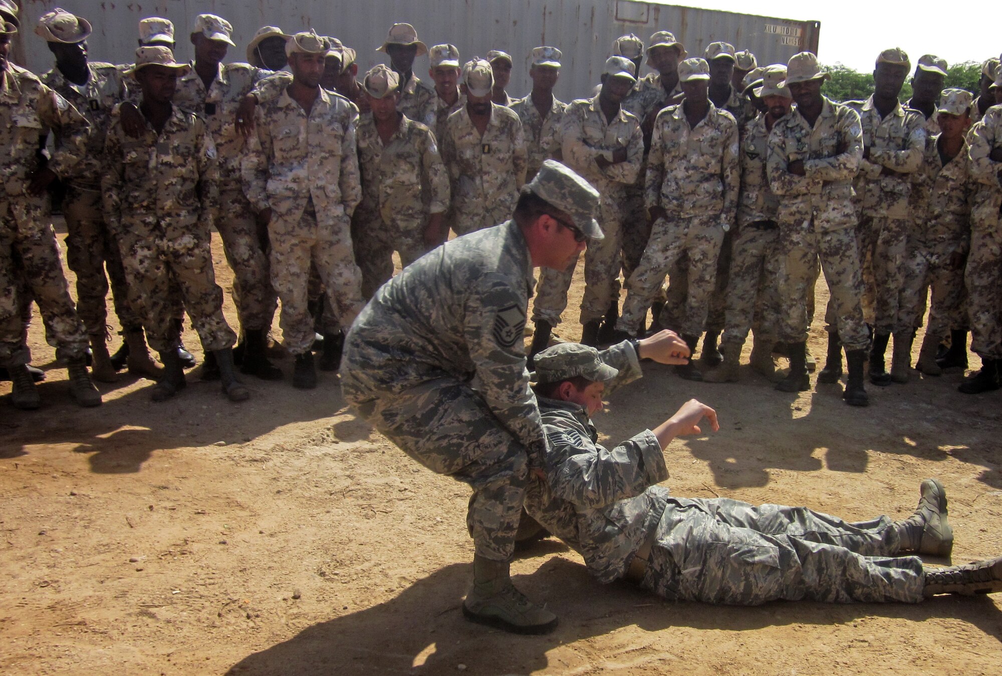 From left, Master Sgt. Joseph Gonzales and Tech. Sgt. Mark Reinecke, 818th Mobility Support Advisory Squadron air advisors, demonstrate combat casualty care to Mauritanian Airmen at Nouakchott Air Base, Nouakchott, Mauritania, Apr. 24, 2014. The 818 MSAS conducted security, supply and logistics training to more than 80 Mauritanian Airmen, April 20 – May 3. (Courtesy photo)