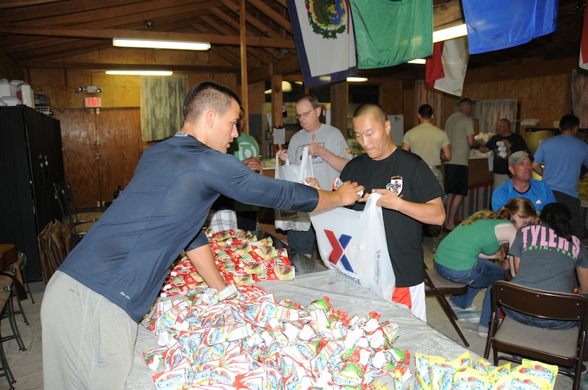 Joint Task Force - Bravo service members pack food and supplies to be given to local Honduran villagers.  More than 120 members of Joint Task Force-Bravo, with the support of Joint Task Force-Bravo's Joint Security Forces and the Honduran military, completed a volunteer seven mile round trip hike to deliver 2,500 pounds of food and supplies to families in need in the mountain village of El Tamarindo outside Comayagua, Honduras, May 17, 2014.  The effort was part of the 54th Joint Task Force-Bravo Chapel Hike, a venerable tradition during which Task Force members donate money to purchase food and supplies and then carry those supplies on a hike through the mountains to deliver them to local, underserviced communities.  (Photo by U. S. National Guard Capt. Steven Stubbs)
