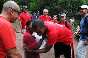 A Honduran woman gives a Joint Task Force-Bravo member a thank you kiss for the food and supplies that she received from him.  More than 120 members of Joint Task Force-Bravo, with the support of Joint Task Force-Bravo's Joint Security Forces and the Honduran military, completed a volunteer seven mile round trip hike to deliver 2,500 pounds of food and supplies to families in need in the mountain village of El Tamarindo outside Comayagua, Honduras, May 17, 2014.  The effort was part of the 54th Joint Task Force-Bravo Chapel Hike, a venerable tradition during which Task Force members donate money to purchase food and supplies and then carry those supplies on a hike through the mountains to deliver them to local, underserviced communities.  (Photo by U. S. Air National Guard Capt. Steven Stubbs)
