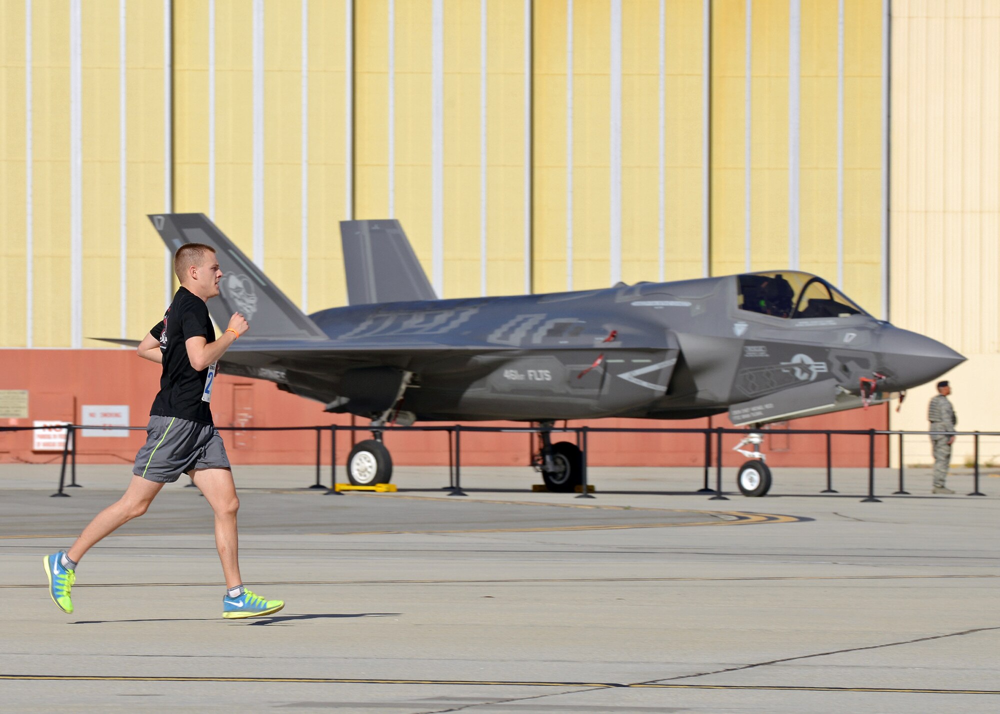Airman 1st Class Austin Duncan, 412th Medical Operations Squadron aerospace medical technician runs past an F-35B during the 2014 Edwards Inaugural "Run with History" Half Marathon on May 17. This F-35B was just one of many aircraft that were on display for runners to see while they ran. Duncan also finished first in the men’s division in the half marathon. (U.S. Air Force photo by Jet Fabara)