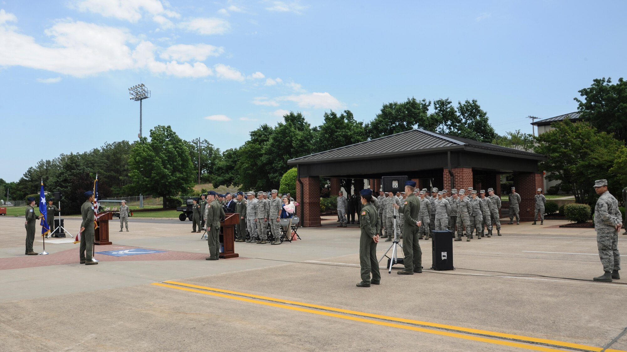 Tech. Sgt. Calvin Jones, noncommissioned officer in charge of protocol, and Senior Airman Katy McGlone, a protocol specialist, stand on the far sides of an event commemorating the arrival of a new C-130J for the 62nd Airlift Squadron May 14, 2014, at Little Rock Air Force Base, Ark. The arrival was one of many base events that have had every detail planned beforehand by protocol. (U.S. Air Force photo by Airman 1st Class Harry Brexel)