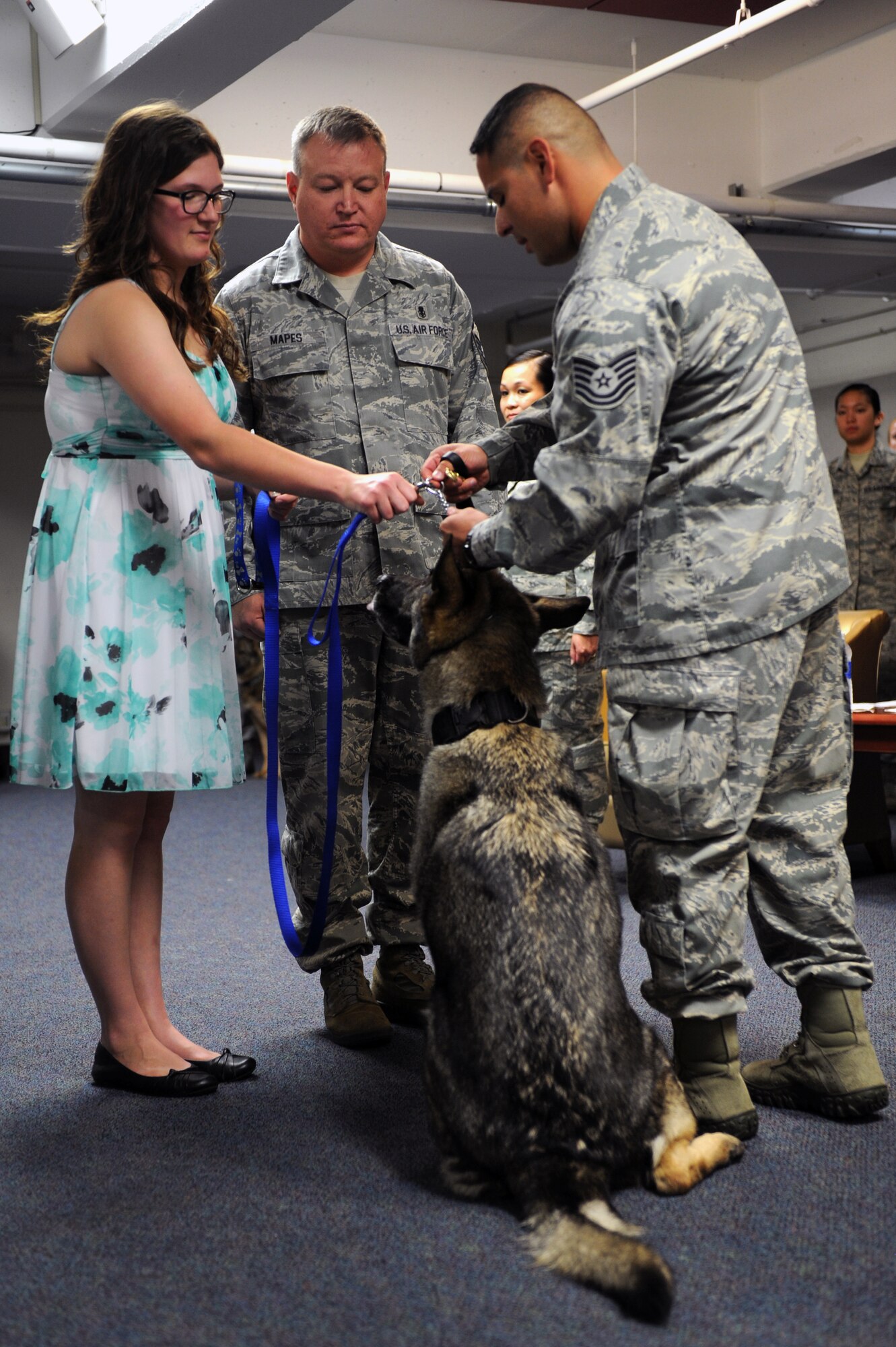 Andor, a retired 22nd Security Forces Squadron military working dog, is officially handed over to retired Master Sgt. Anthony Mapes, 22nd Medical Squadron dental clinic, and his family during a dual retirement ceremony, May 19, 2013, McConnell Air Force Base, Kan. Mapes recently adopted Andor, who was medically retired and sent through a MWD transitioning program.  (U.S. Air Force photo/ Airman 1st Class Aaron-Forrest Wainwright)