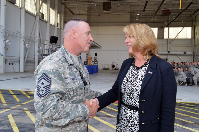 Command Chief Master Sgt. Rocky Hart, 440th Airlift Wing command chief, presents Secretary of the Air Force Deborah Lee James with his coin after James' "all call" with Pope Airmen on May 19. James received mission briefings from Pope commanders, toured facilities, and had lunch with Airmen during her one-day visit. (U.S. Air Force photo/Marvin Krause)
