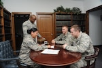 From left: Staff Sgt. Nelly Hensley, NCO in charge of Military Justice, and Tech. Sgt. Jason Brown, NCO in charge of the legal office, assist 2nd Lt. Donald Kidwell and 2nd Lt. Cody Shilling May 8 with the process of executing a will. (U.S. Air Force photo by Melissa Peterson)

