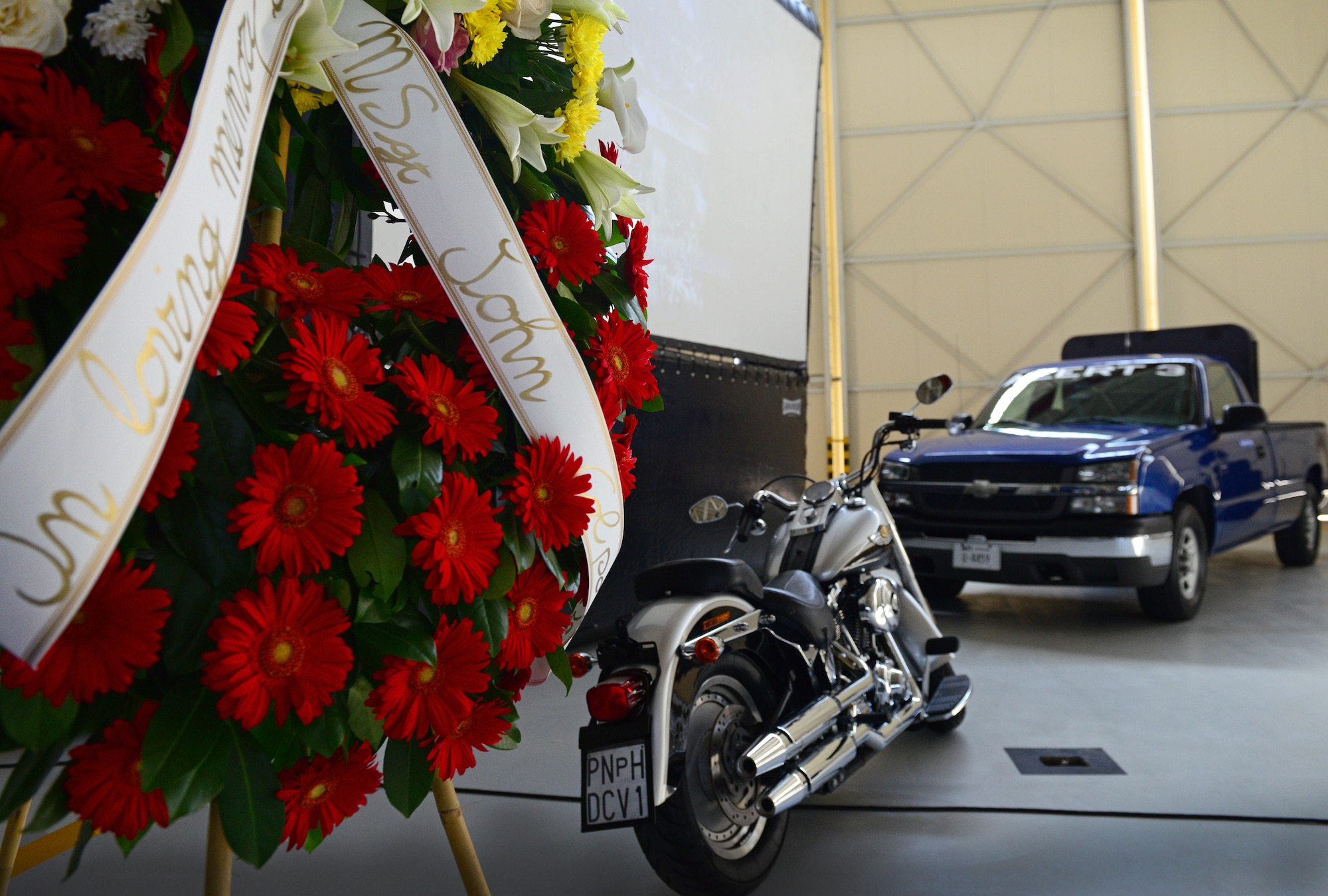 A motorcycle and transient alert truck are displayed during Master Sgt. John Colpoys’ memorial service, May 22, 2014, at Aviano Air Base, Italy. During the service, a moment of silence was observed while taps sounded and "Amazing Grace" was played. (U.S. Air Force photo/Airman 1st Class Ryan Conroy)