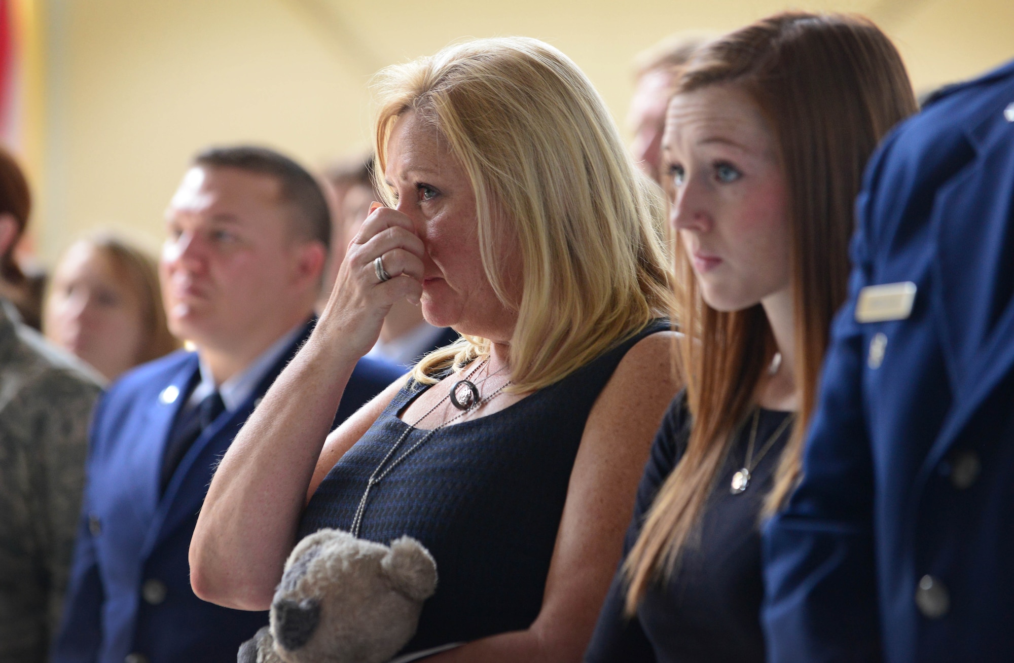 Lisa Colpoys listens as a letter she wrote for the memorial service is read aloud, May 22, 2014, at Aviano Air Base, Italy. Hundreds of Aviano Airmen were in attendance for the memorial service of Master Sgt. John Colpoys, 31st Maintenance Squadron transient alert member. (U.S. Air Force photo/Senior Airman Matthew Lotz)