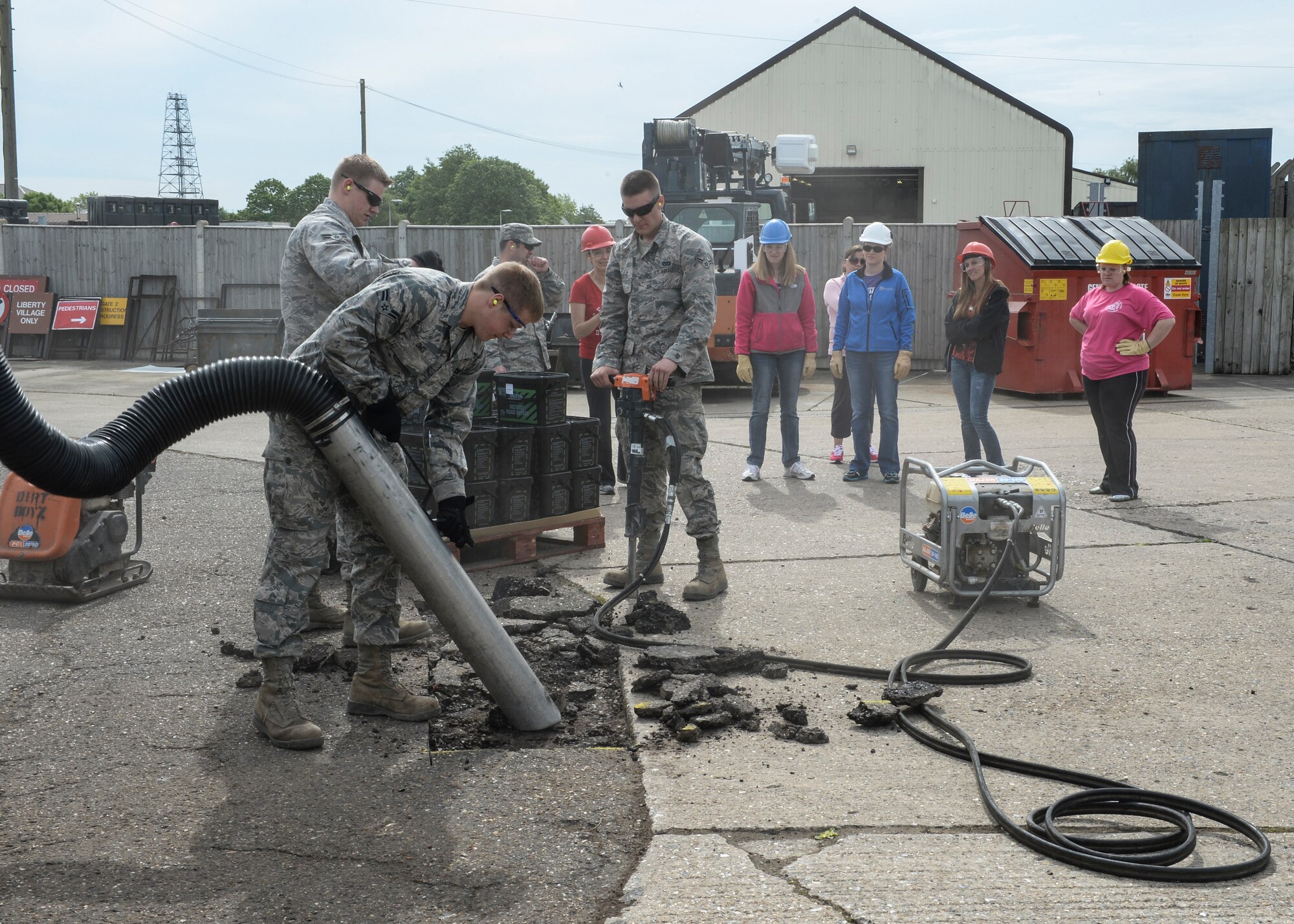 Airmen from the 48th Civil Engineer Squadron demonstrate the proper way to clear a construction area during Take Your Spouse to Work Day on Royal Air Force Lakenheath, England, May 21, 2014. Airmen maintain a clean working area during construction to ensure the accuracy of their work. (U.S. Air Force photo by Airman 1st Class Nigel Sandridge/Released)