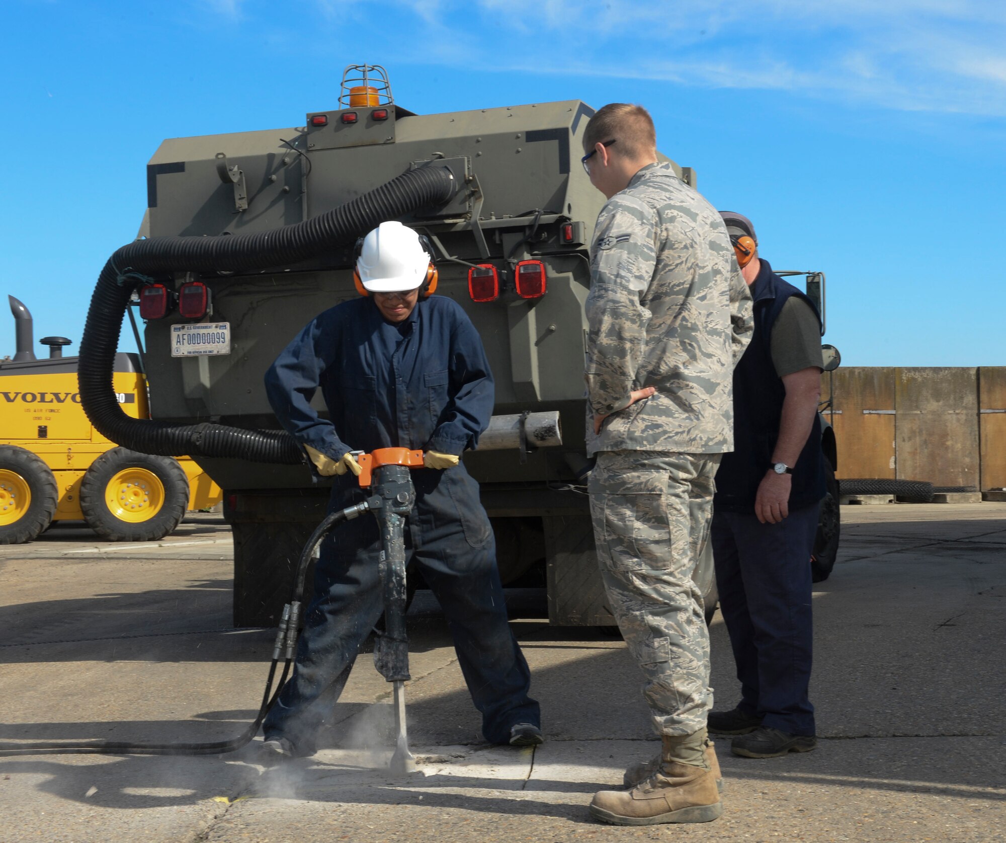 Sarah Hade, wife of Airman Cody Hade, 48th Civil Engineer Squadron heavy equipment operator, uses a jack hammer to break concrete during Take Your Spouse to Work Day on Royal Air Force Lakenheath, England, May 21, 2014. Spouses learned proper techniques to effectively use the same machines that their Airmen use on a daily basis. (U.S. Air Force photo by Airman 1st Class Nigel Sandridge/Released)