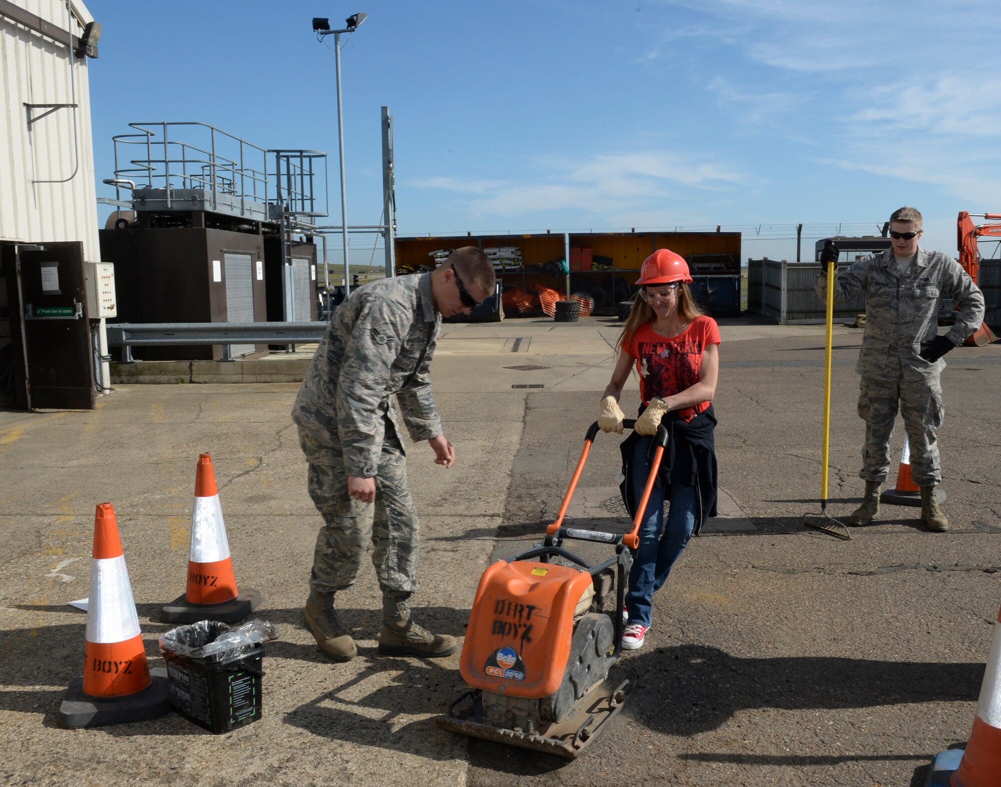 Airmen from the 48th Civil Engineer Squadron show a spouse how to use a pneumatic tamper during Take Your Spouse to Work Day on Royal Air Force Lakenheath, England, May 21, 2014. Pneumatic tampers are used to smooth newly-repaired holes to the same level as the orignal surface. (U.S. Air Force photo by Airman 1st Class Nigel Sandridge/Released)