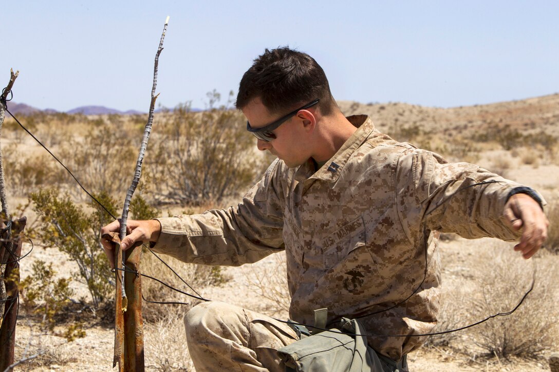 Marine Corps Capt. John Jurinek builds a shelter during a tactical recovery of aircraft and personnel mission while participating in Exercise Desert Scimitar 2014 on Marine Corps Air Ground Combat Center Twentynine Palms, Calif., May 12, 2014. Jurinek, a logistics officer, is assigned to 1st Marine Division's Headquarters Battalion, 1st Marine Expeditionary Force.