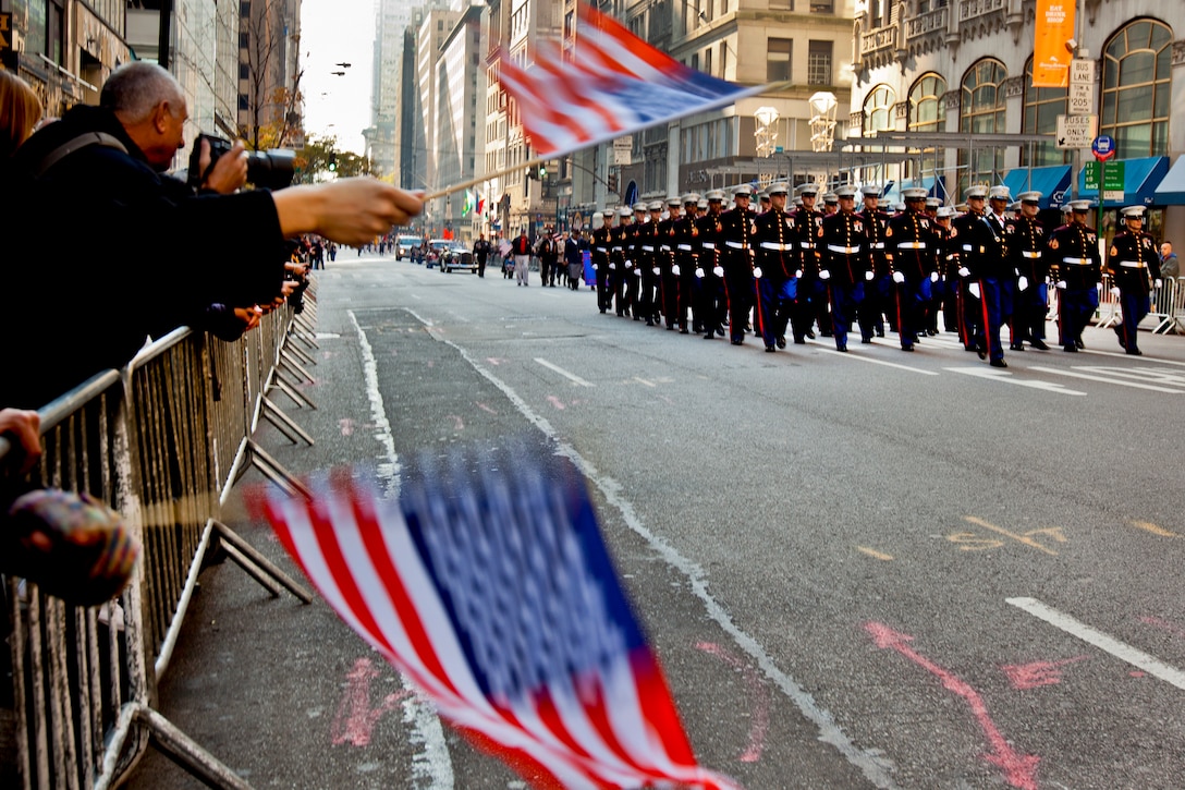 A New York crowd waves flags and cheers for Marines as they marched in the annual Veterans Day parade in New York, Nov. 11, 2012. Since Nov. 11, 1919, the parade has provided an opportunity for Americans and international visitors in the nation's largest city to honor those who have served. The Marines are assigned to the 6th Communications Battalion, Marine Forces Reserve. 
