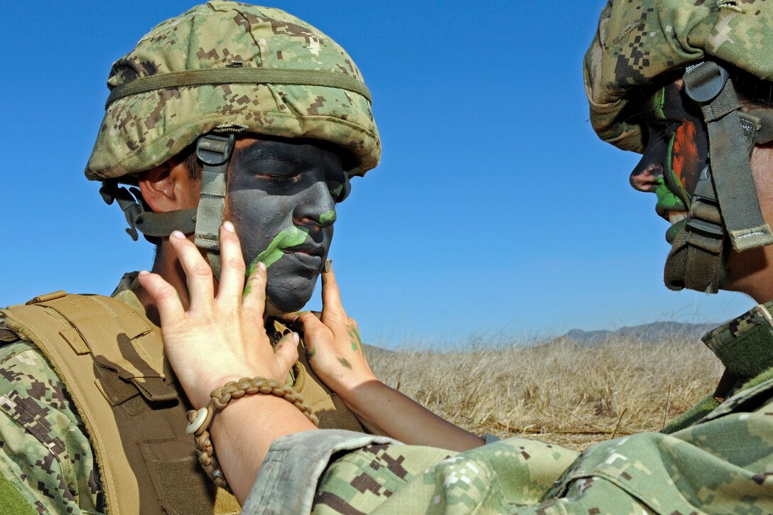 Navy Seaman Recruit Michael Torres, left, has his face painted to help camouflage him during a field training exercise on Camp Pendleton, Calif., Nov. 6, 2012. The Amphibious Construction Battalion 1 provides logistical over-the-shore support for amphibious forces and maritime force operations, including ship-to-shore transportation of combat cargo, bulk fuel and water, and tactical camp operations.  
