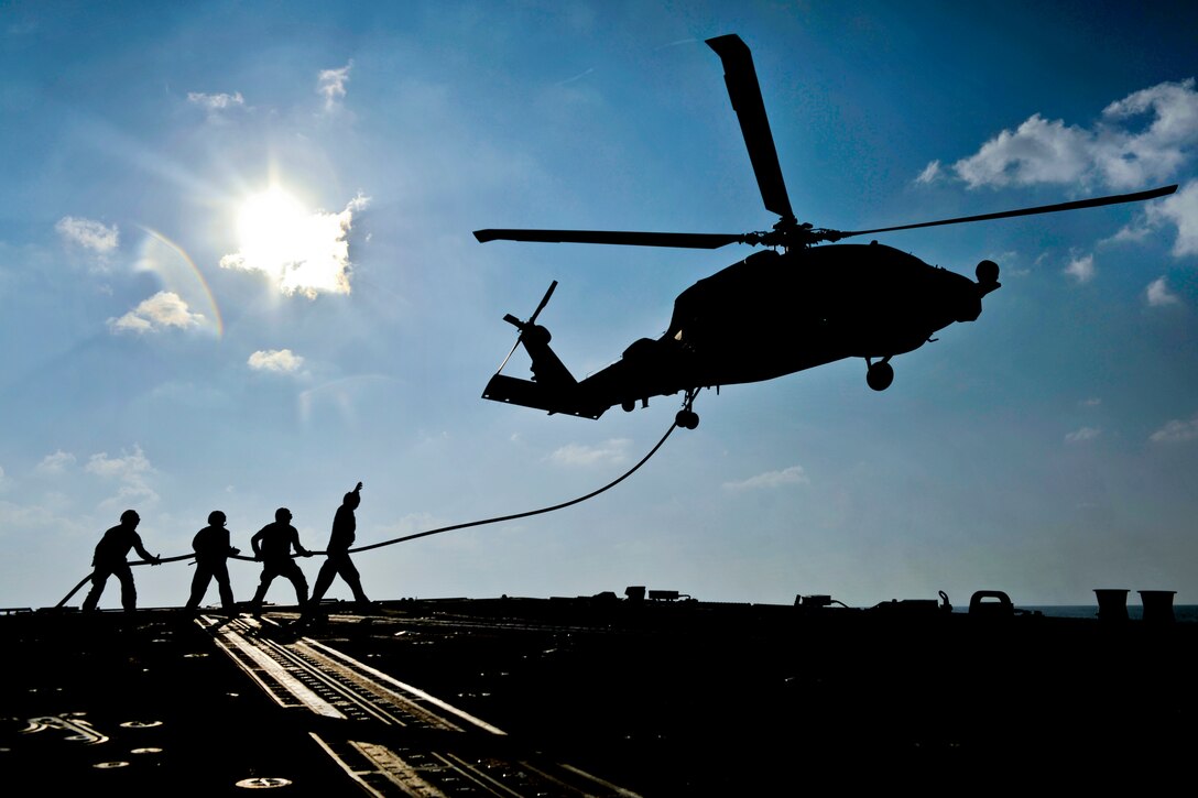 U.S. Navy sailors aboard the guided-missile destroyer USS Jason Dunham hold a fuel hose during the refueling of an SH-60B Seahawk helicopter while it flies in the Arabian Sea, Nov. 5, 2012. The Jason Dunham is deployed to the U.S. 5th Fleet area of responsibility conducting maritime security operations, theater security cooperation efforts and support missions for Operation Enduring Freedom. The helicopter is assigned to Helicopter Anti-submarine Squadron Light 42.  
