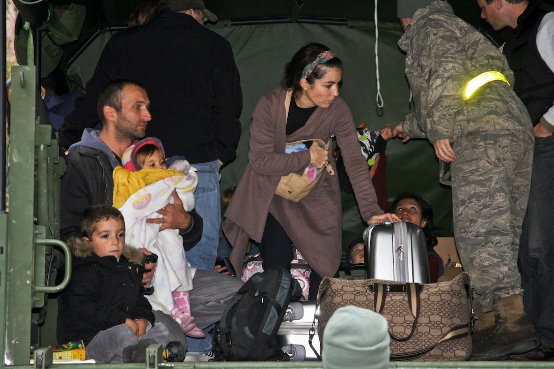 A soldier assists a family displaced by Hurricane Sandy in Hoboken, N.J., Oct. 31, 2012. The soldier is assigned to the New Jersey National Guard. 
