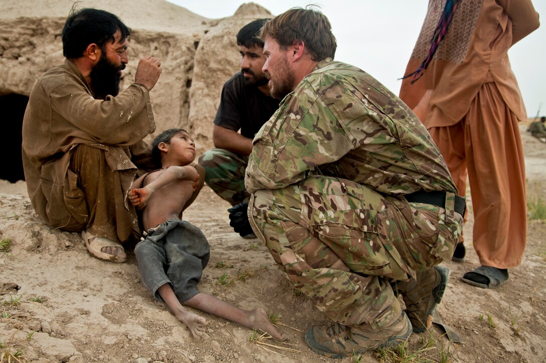 A coalition force member assesses a child's health during an Afghan-led security patrol to deny freedom of movement for the enemy in Khak-E-Safed in Afghanistan's Farah province, Oct. 30, 2012. Afghan forces have been taking the lead in security operations, with coalition forces as mentors to bring security and stability to the country's people.  
