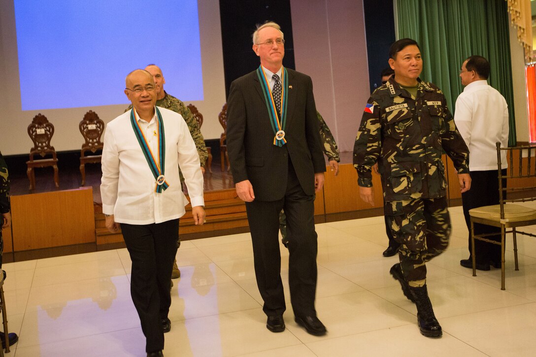 (Left to right) The honorable Under Secretary of National Defense Honorio S. Azcueta, Deputy Chief of Mission for the U.S. Embassy Brian L. Goldbeck and Philippine Army Gen. Emmanuel T. Bautista, chief of staff of the Armed Forces of the Philippines, lead the procession of the exercise Balikatan 2014 closing ceremony here May 16. The ceremony marked the official closing of the 30th iteration of Balikatan, an annual bilateral exercise which aims to increase interoperability and strengthen the Philippines-U.S. relationship. (Official U.S. Marine Corps photo by Sgt. Isis M. Ramirez)