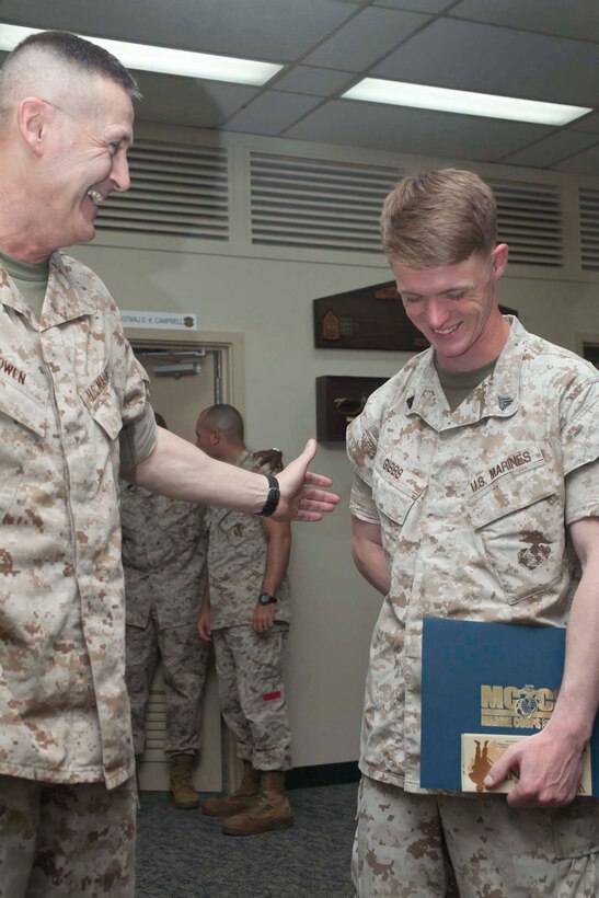 Col. Edmund J. Bowen, left, shares a laugh with Cpl. Joel A. Gibbs after presenting him with a Marine Corps Community Service Individual Augmentee Welcome Home package May 13 at Camp Kinser. “It’s a refreshing feeling knowing that the work I did there was appreciated,” said Gibbs, a Logansport, Ind., native. Bowen is the commanding officer of Combat Logistics Regiment 37, and Gibbs is a landing support specialist with CLR-37, 3rd Marine Logistics Group, III Marine Expeditionary Force. (U.S. Marine Corps photo by Sgt. Anthony J. Kirby/Released) 