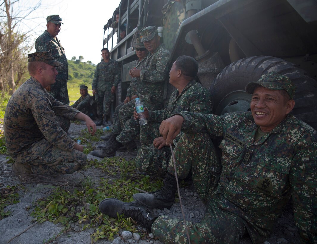 U.S. Marine Sgt. Jesse B. Boydston, left, takes a moment to relax with Philippine Marines during a training event May 12, 2014 as part of Balikatan 2014. The training was part of the culminating event between the logistics combat element of U.S. Marine Forces Balikatan and the Philippine Marines. Balikatan is an annual training exercise that strengthens the interoperability between the Armed Forces of the Philippines and U.S. military and their commitment to regional security and stability, humanitarian assistance and disaster relief. Boydston is wrecker chief of 3rd Maintenance Battalion, 3rd Marine Logistics Group, III Marine Expeditionary Force. The Philippine Marines are with Motor Transport and Maintenance Battalion, Combat Service Support Brigade, Philippine Marine Corps. (U.S. Marine Corps photo by Lance Cpl. Joey S. Holeman/Released)