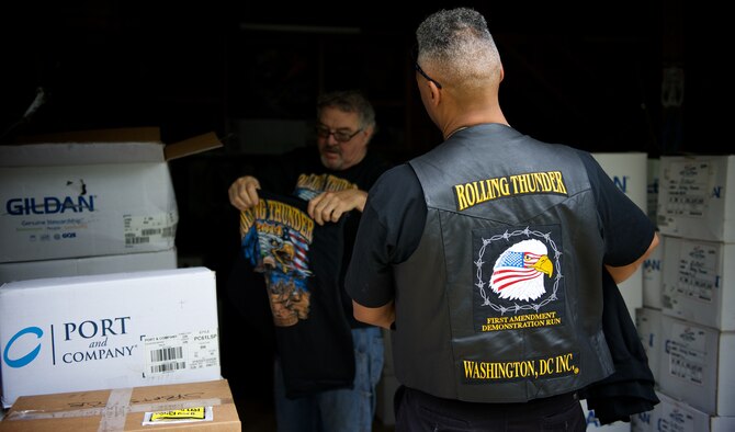 Rob Wilkins, front, and Walt Sides inspect a recent shipment of 2014 souvenir t-shirts for the Rolling Thunder motorcycle demonstration event May 15, 2014 at Sides' farm outside Leesburg, Va. Wilkins is head of Rolling Thunder Magazine and a retired Air Force master sergeant. Sides, a retired Marine first sergeant, original co-founder and executive director of Rolling Thunder, has organized the event since 1988. (U.S. Air Force photo/Senior Airman Alexander W. Riedel)
