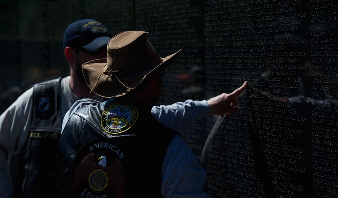 Two military veterans visit the Vietnam Memorial during Rolling Thunder May 26, 2013, in Washington, D.C. Rolling Thunder is a one-day remembrance demonstration motorcycle run from the Pentagon to the nations war memorials. Many veterans visit the rally to see the names of their lost comrades. (U.S. Air Force photo/Senior Airman Alexander W. Riedel)