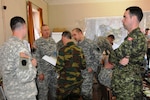 The 28 ID Chief of Plans Lt. Col. Michael Wegscheider, second from left, and plans officer Maj. John Tippett review exercise battle plans with Belgian Kapitein Nicolas Six and Canadian Maj. Marc-Andre Langelier, right. 