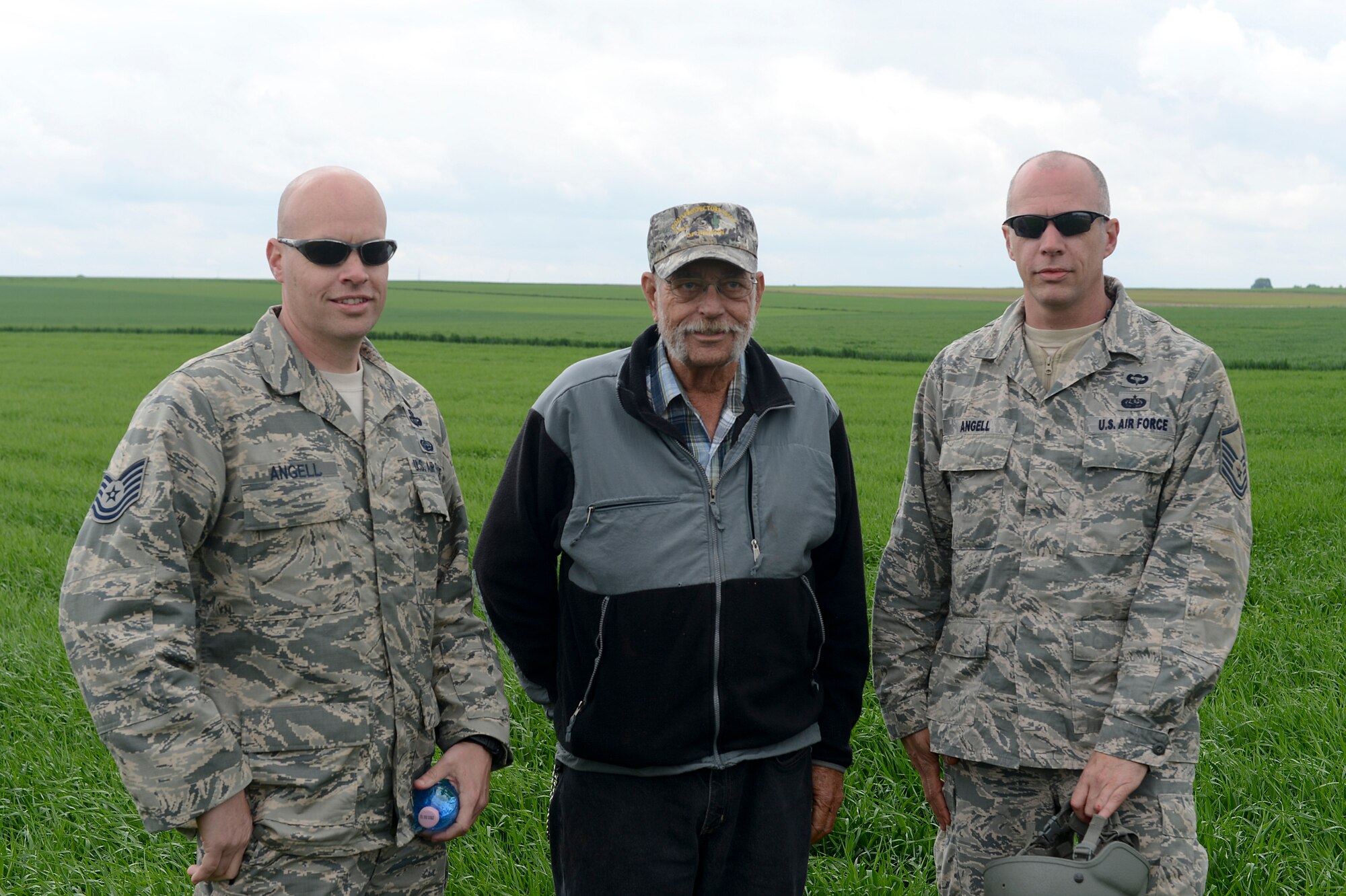 Tech. Sgt. Brian Angell, left, and Master Sgt. Kevin Angell, right, stand with their father, Sam Angell, center, May 8, 2014, during International Jump Week at Alzey landing zone, Germany. Sam Angell flew from Florida to Germany, to see his sons jump together for the first time in both of their careers. (U.S. Air Force photo/Airman 1st Class Michael Stuart)