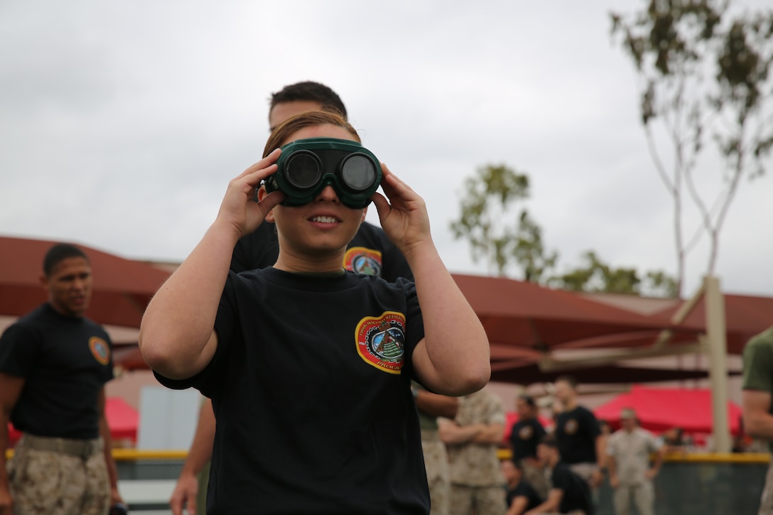 MARINE CORPS AIR STATION MIRAMAR, Calif. – Lance Cpl. Loryn Graham, weather forecaster with Headquarters and Headquarters Squadron, looks through “beer goggles” in preparation of the “Dizzy Izzy” competition during the Stronger Warrior Field Meet at Marine Corps Air Station Miramar, Calif., May 22. The “Dizzy Izzy” involved putting on “beer goggles”, which simulated being intoxicated for those who wore them, and sprinting from one point to another. 