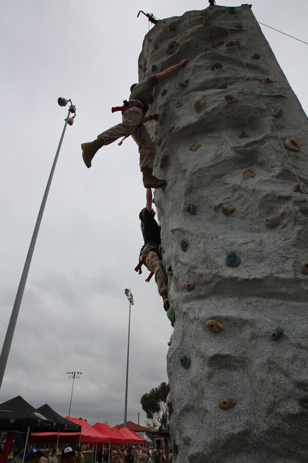 MARINE CORPS AIR STATION MIRAMAR, Calif. – Staff Sgt. David Nadrchal, company gunnery sergeant with Marine Wing Communications Squadron (MWCS) 38, top, and Cpl. Kyle Stresemann, track operator with MWCS-38, compete in rock climbing during the Stronger Warrior Field Meet at Marine Corps Air Station Miramar, Calif., May 22. The meet was part of the 101 Days of Summer program and focused on bringing awareness to various health and fitness issues.