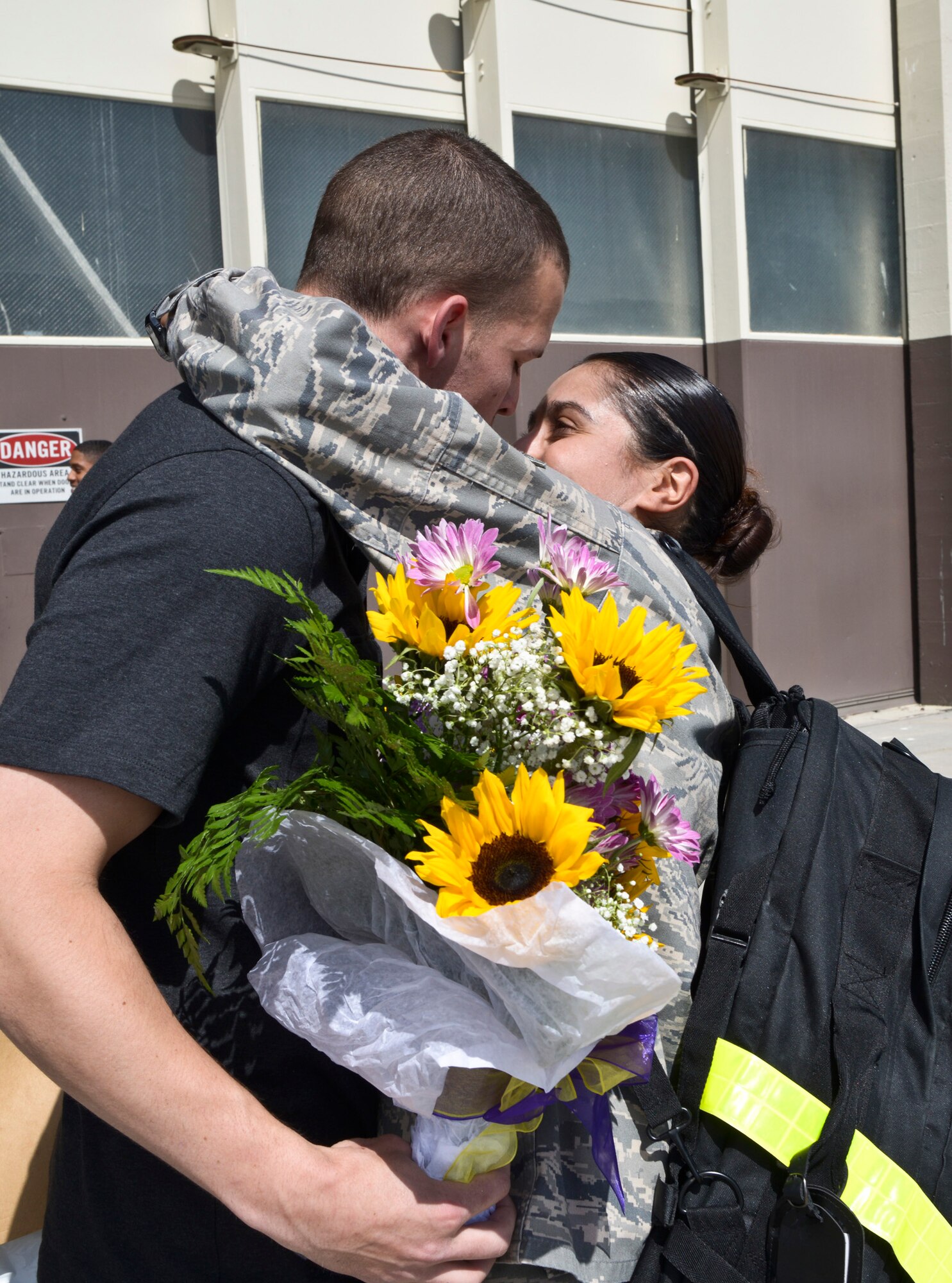 A 726th Air Control Squadron Airman hugs his wife and daughter after returning from deployment to Afghanistan May 23, 2014. 'Hardrock' Airmen provided time critical battle management command and control using sensors and communication located across Afghanistan. (U.S. Air Force photo by Master Sgt. Kevin Wallace/RELEASED)