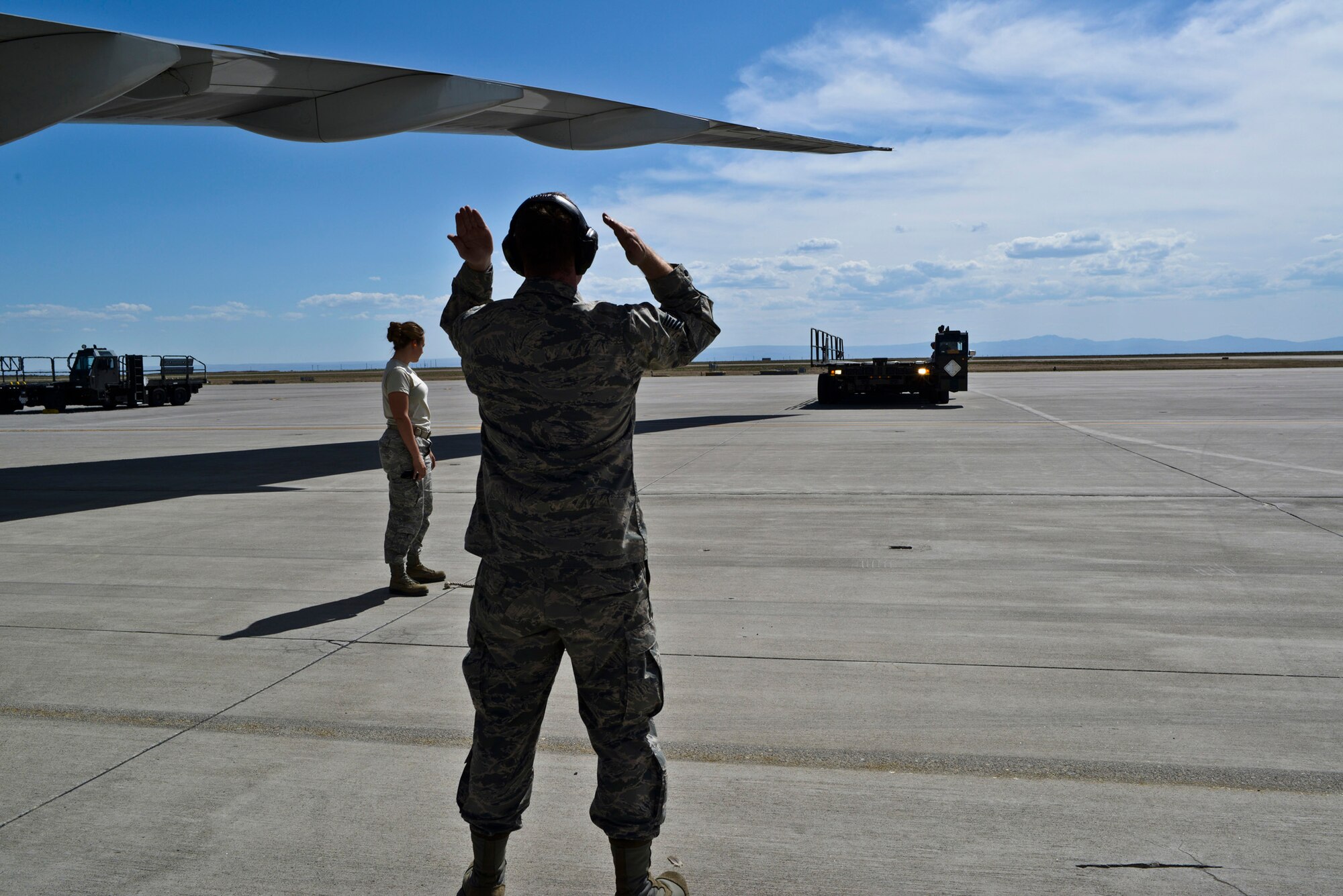 Tech. Sgt. Daniel Hill, 366th Logistics Readiness Squadron, marshals a k-loader into place so the LRS team can unload baggage from 726th Air Control Squadron Airmen, who returned from deployment to various locations in Afghanistan and Southwest Asia, and were reunited with family and friends at a celebration at the Mountain Home Air Force Base flightline, May 23, 2014, at the base in Southwestern Idaho. Mountain Home is a total-force team and despite the 726th ACS being a tenant unit at the base, the host 366th Fighter Wing and all tenant units enjoy a seamless relationship. (U.S. Air Force photo by Master Sgt. Kevin Wallace/RELEASED)