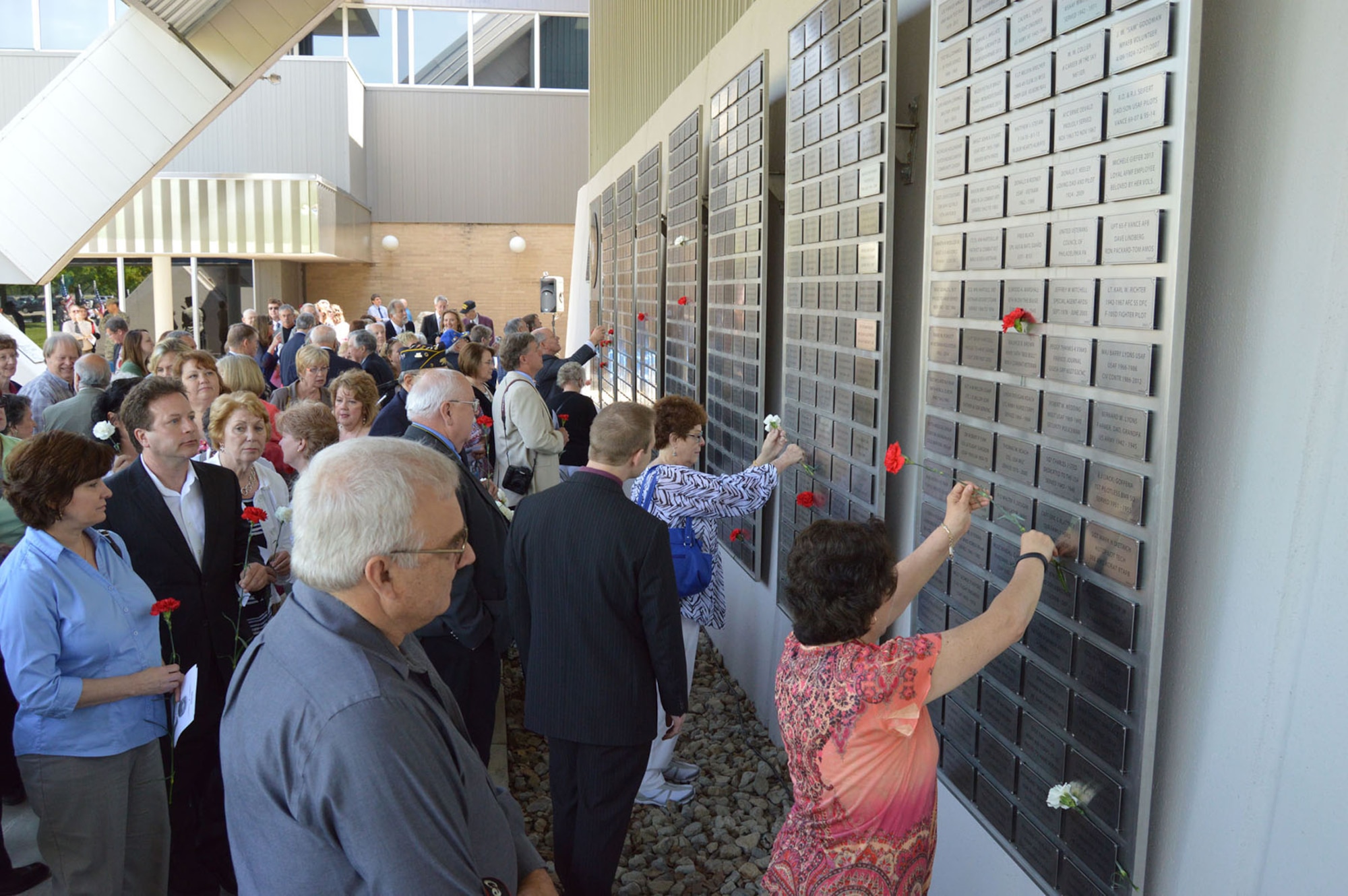 DAYTON, Ohio (05/2014) -- Attendees place flowers on their loved ones plates at the Legacy Data Plate Wall of Honor Tribute Ceremony at the National Museum of the U.S. Air Force. (Photo courtesy of Air Force Museum Foundation)