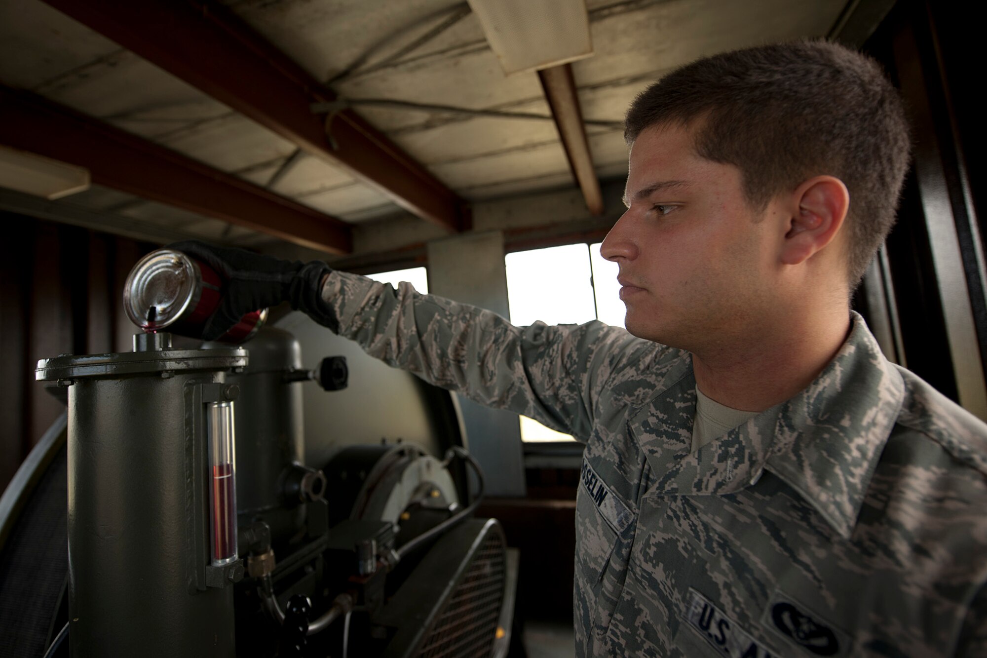 U.S. Air Force Airman 1st Class Daniel Gosselin, 65th Civil Engineer Squadron power production technician, fills the reservoir of an aircraft arresting system with hydraulic fluid during a weekly preventive maintenance inspection May 20, 2014, at Lajes Field, Azores, Portugal. The power production office maintains the AAS to ensure the integrity of the system. In the event of an inflight emergency the AAS will stop an aircraft that is equipped with a tail hook to prevent loss of aircraft and life. (U.S. Air Force photo by Tech. Sgt. Paul Villanueva II/Released)
