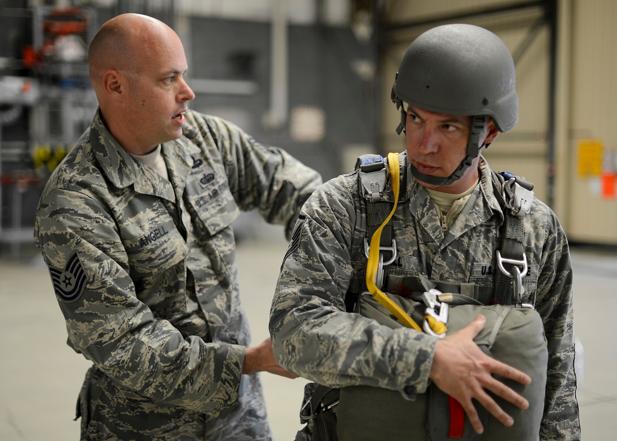 Tech. Sgt. Brian Angell, 435th Contingency Response Group personnel parachute program manager, Tucson Arizona native (left) straps in his older brother into his parachuting equipment, Master Sgt. Kevin Angell, Special Operations Command Korea, NCO in charge of communications directorate, Tucson, Arizona, native, at Ramstein Air Base, Germany, May 8, 2014. Kevin Angell flew in from Korea to jump with his younger brother for the first time in both of their careers. (U.S. Air Force photo/Airman 1st Class Michael Stuart)